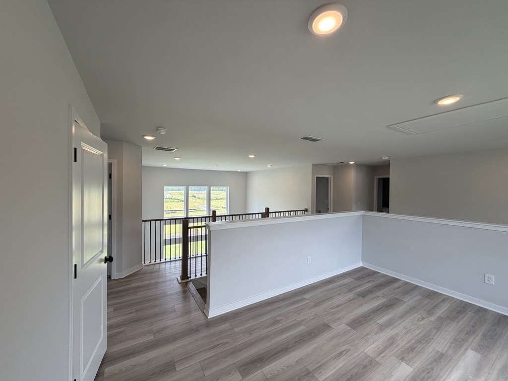 A room with a wood floor and white walls.