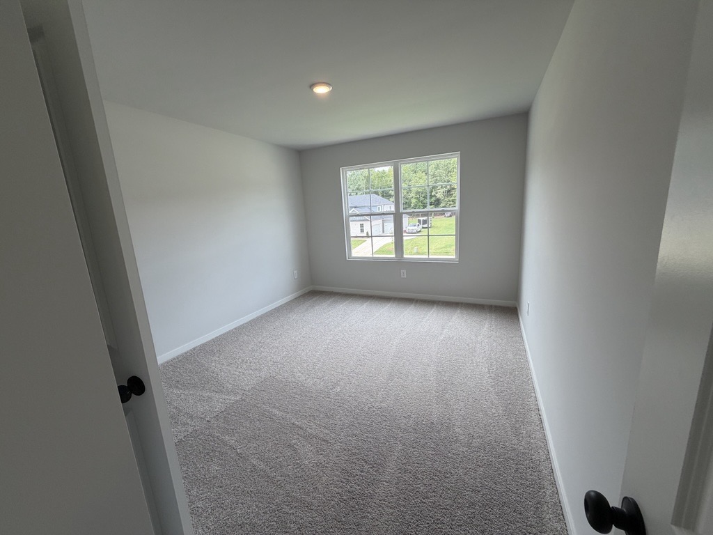 A room with a window and carpet.