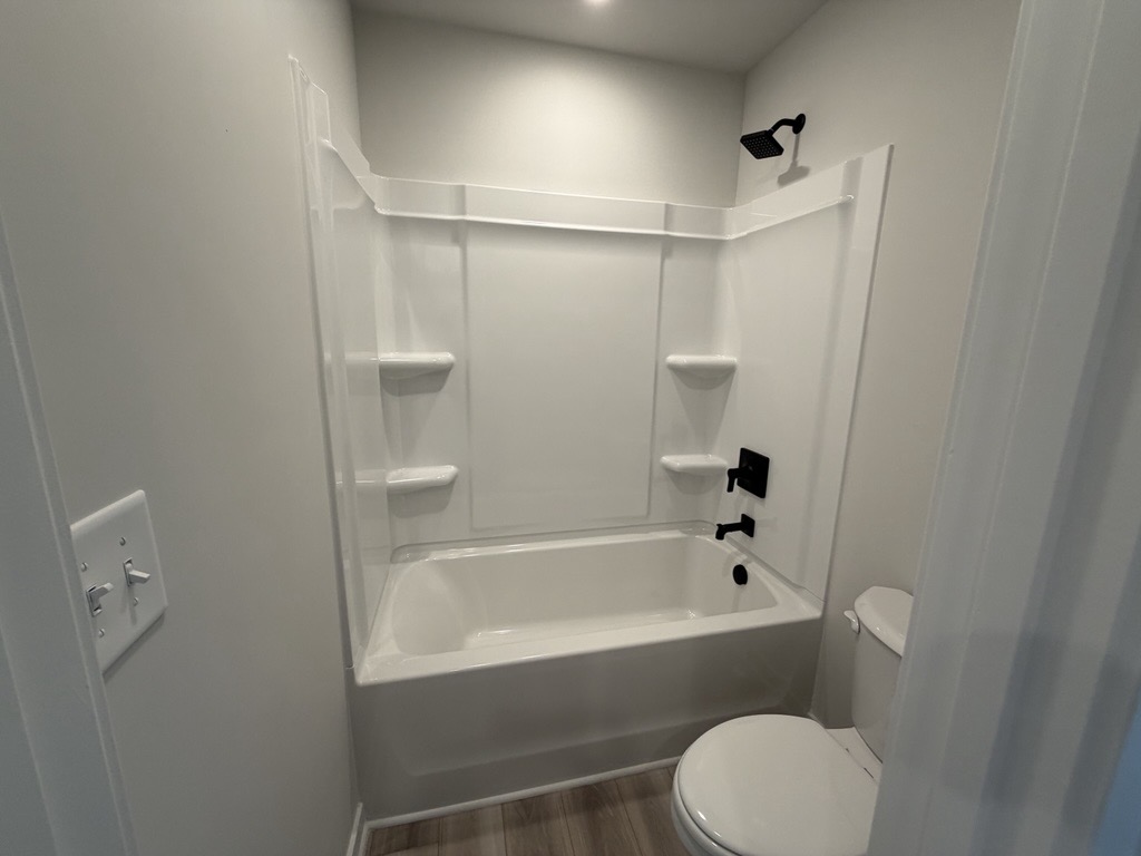 A bathroom with a bathtub and toilet.