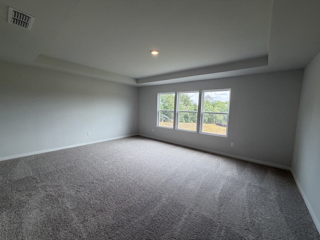 A room with a carpet and a window.