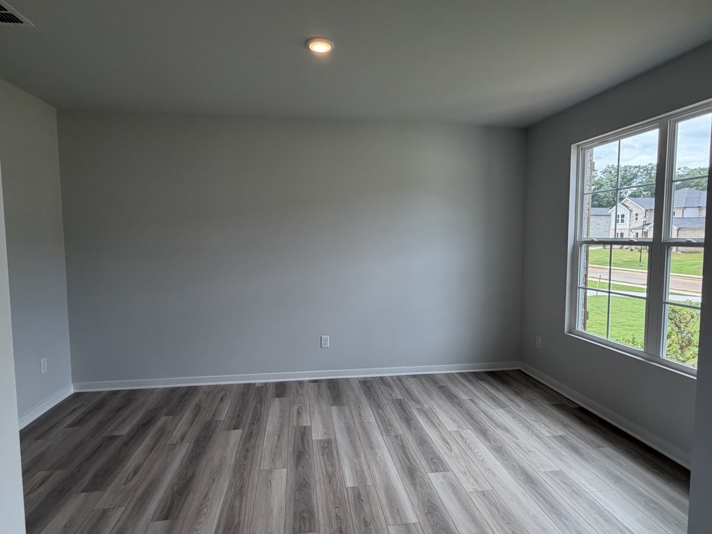 A room with a wood floor and windows.