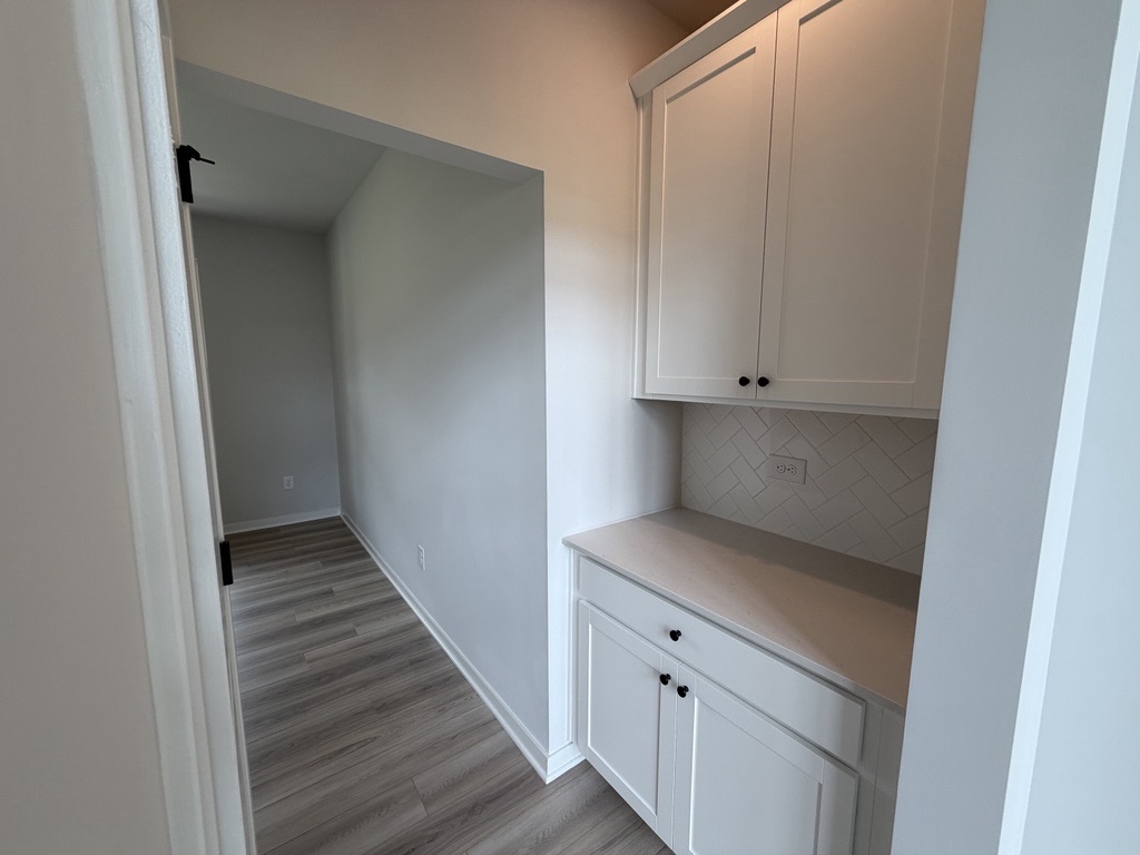 A kitchen with white cabinets.