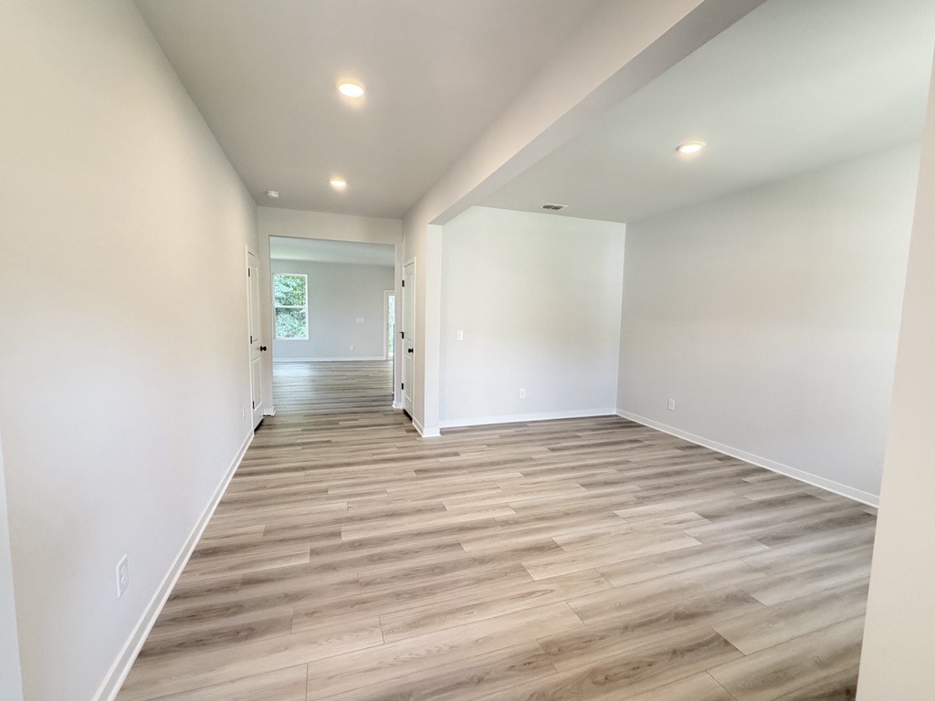 A room with a wood floor and white walls.