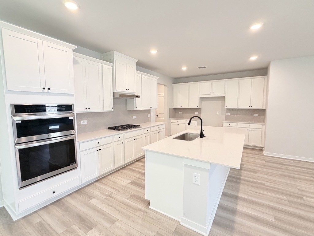 A kitchen with white cabinets.