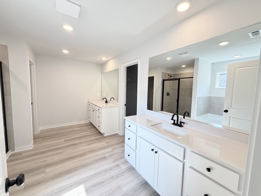 A bathroom with white cabinets.