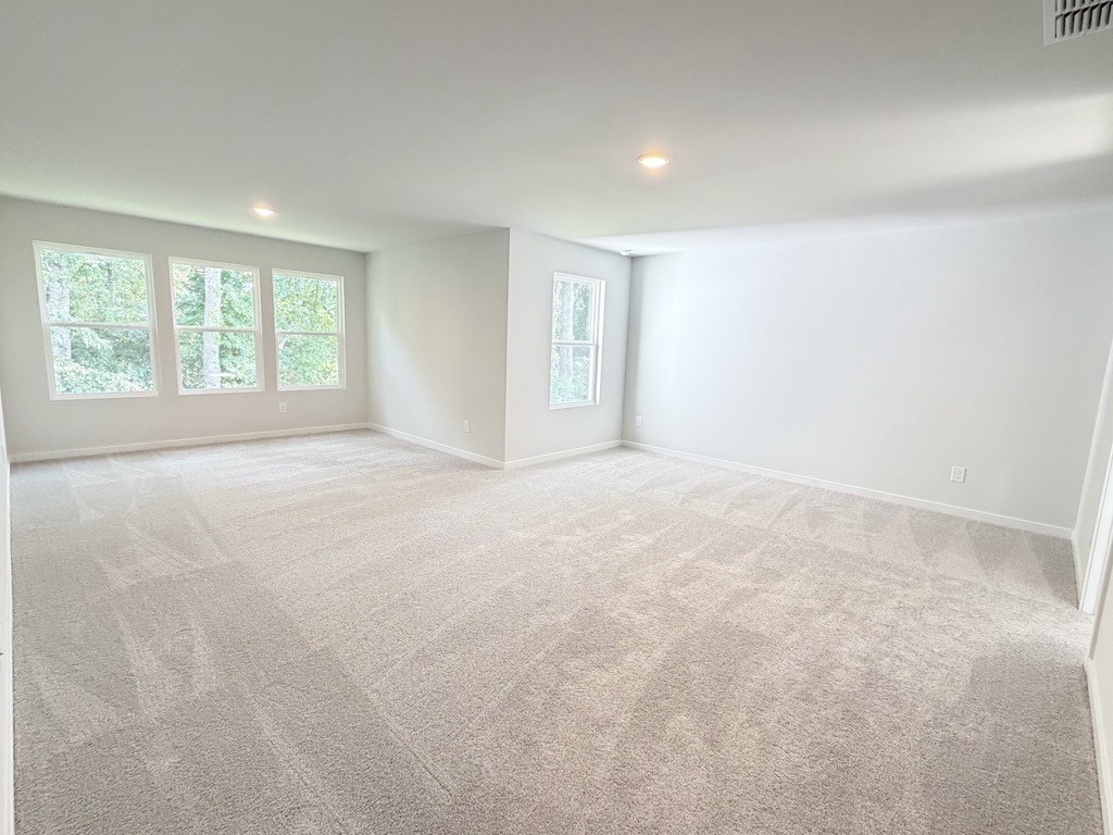 A large empty room with a carpet.