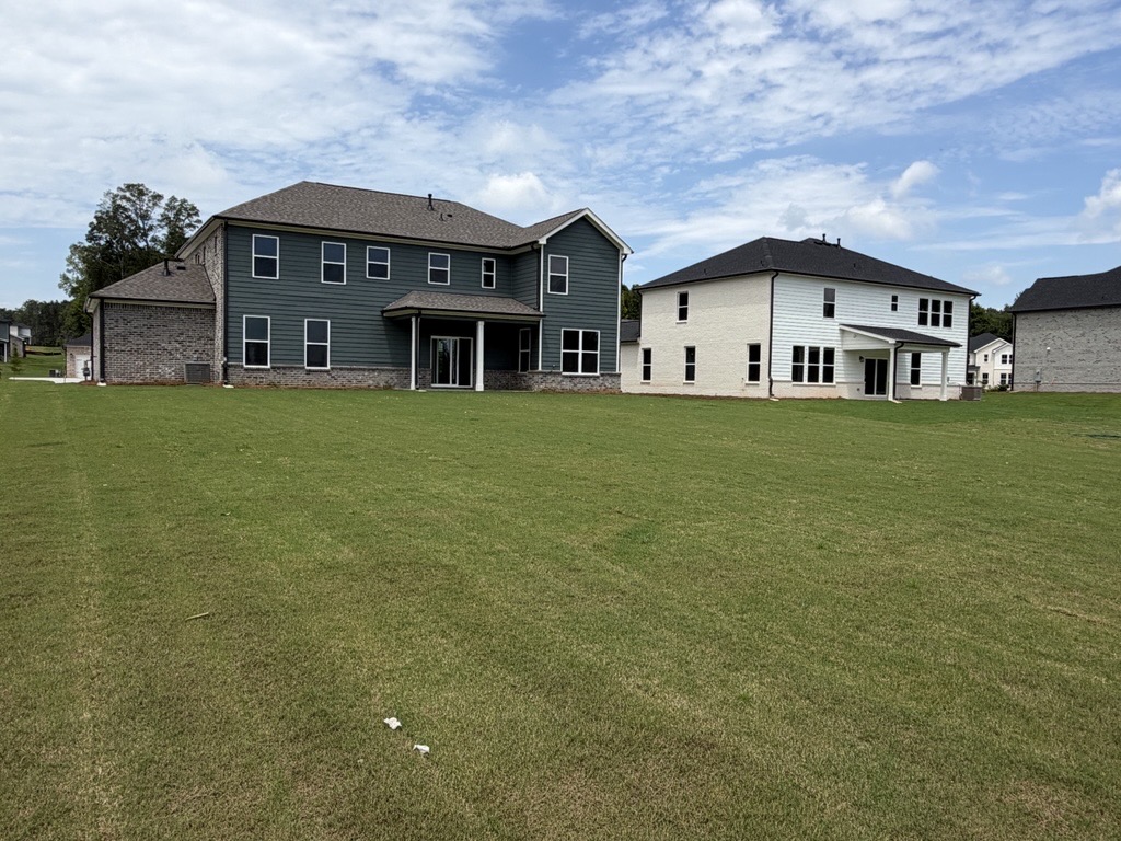 A large house with a lawn in front of it.