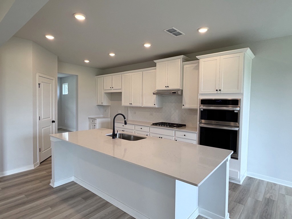 A kitchen with white cabinets.