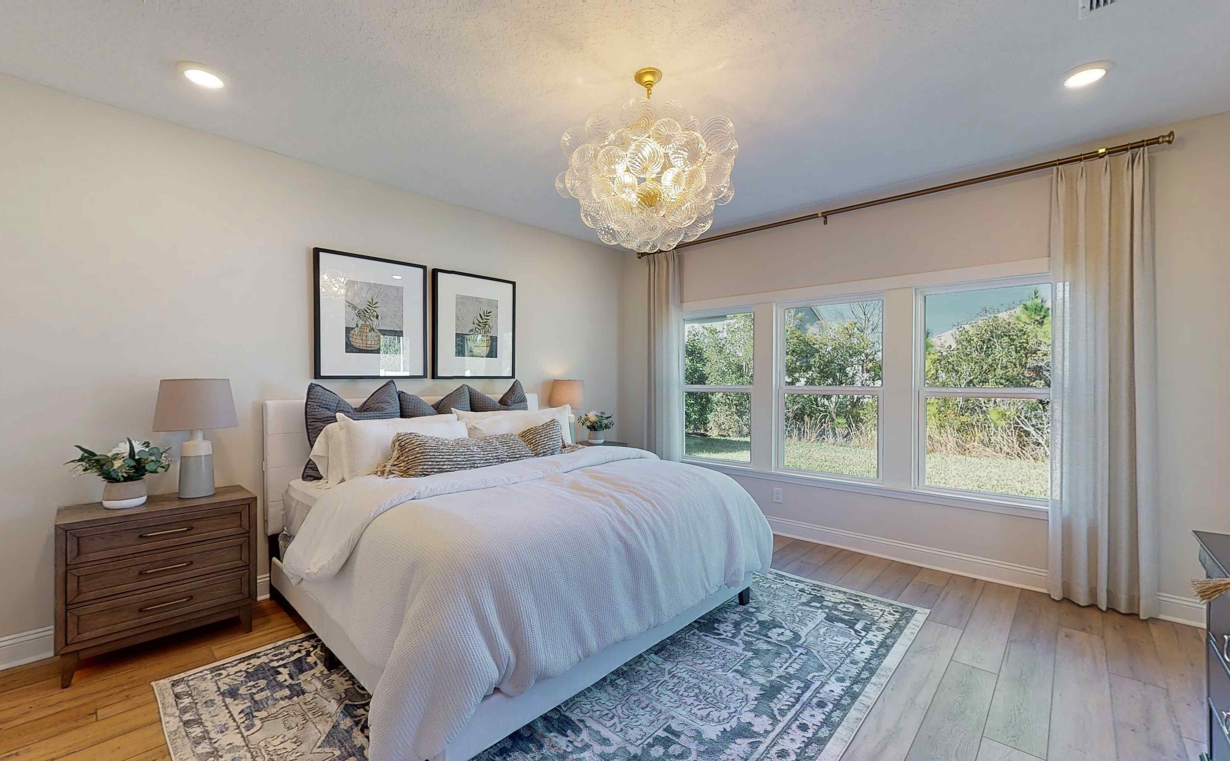 A bedroom with a bed and a chandelier.