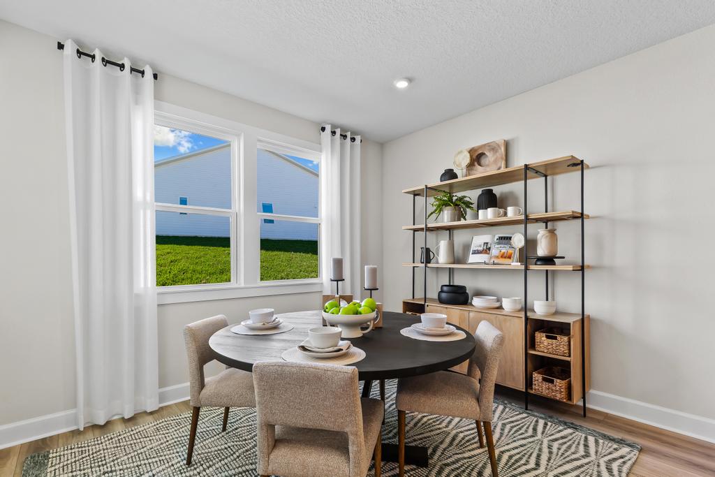 A dining room with a table and chairs.