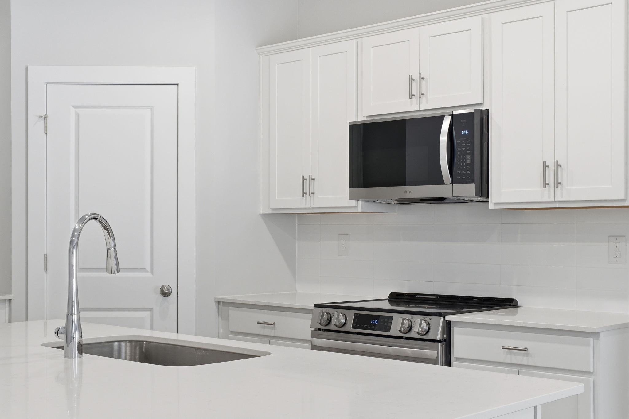 A kitchen with white cabinets.