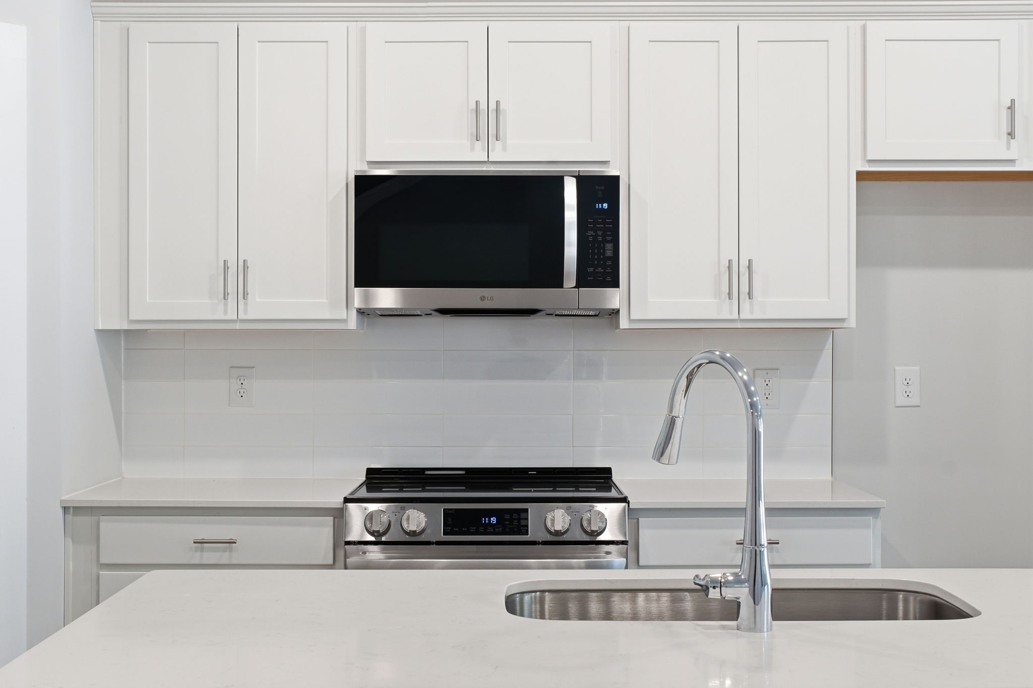 A kitchen with white cabinets.