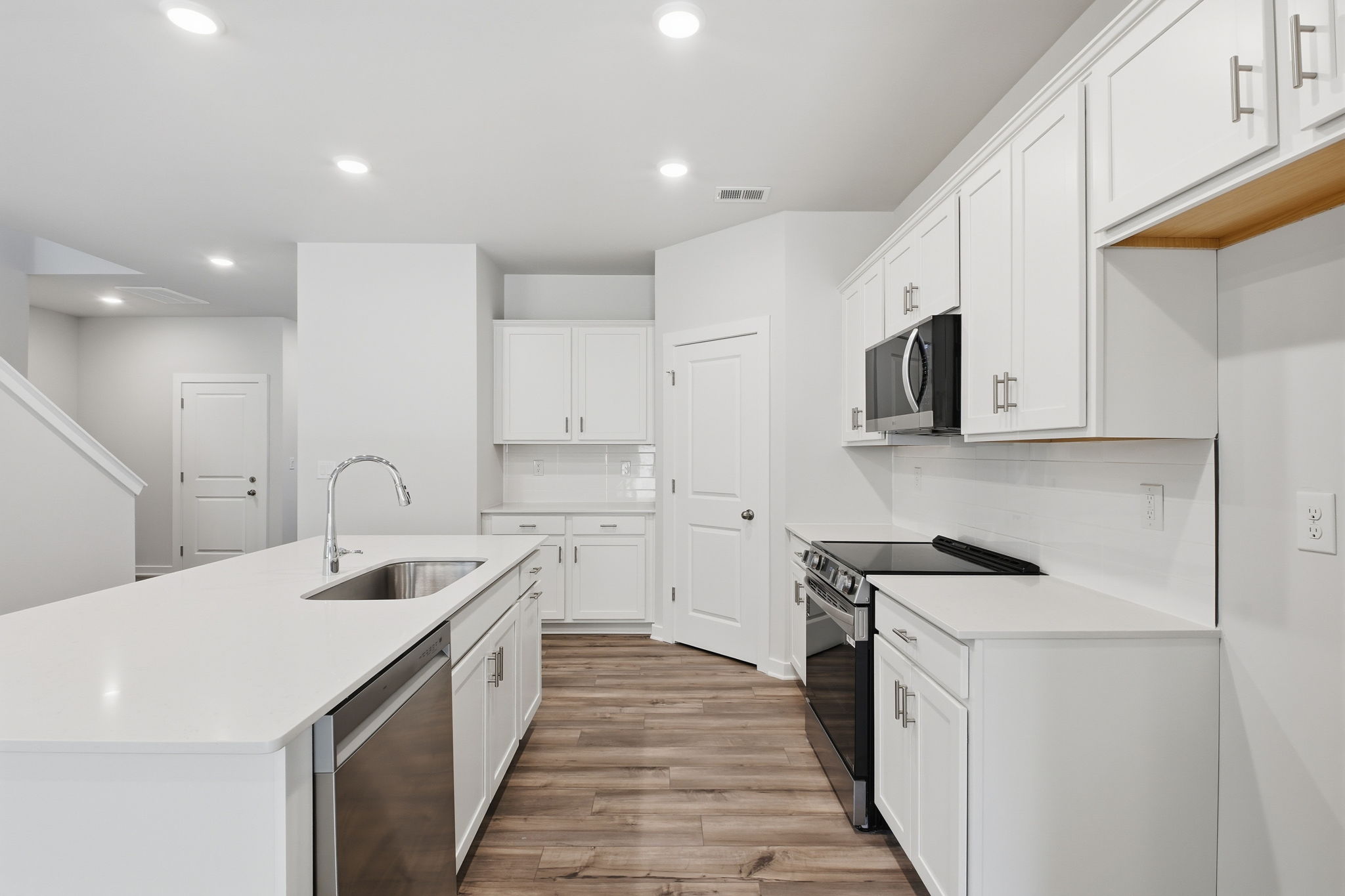 A kitchen with white cabinets.