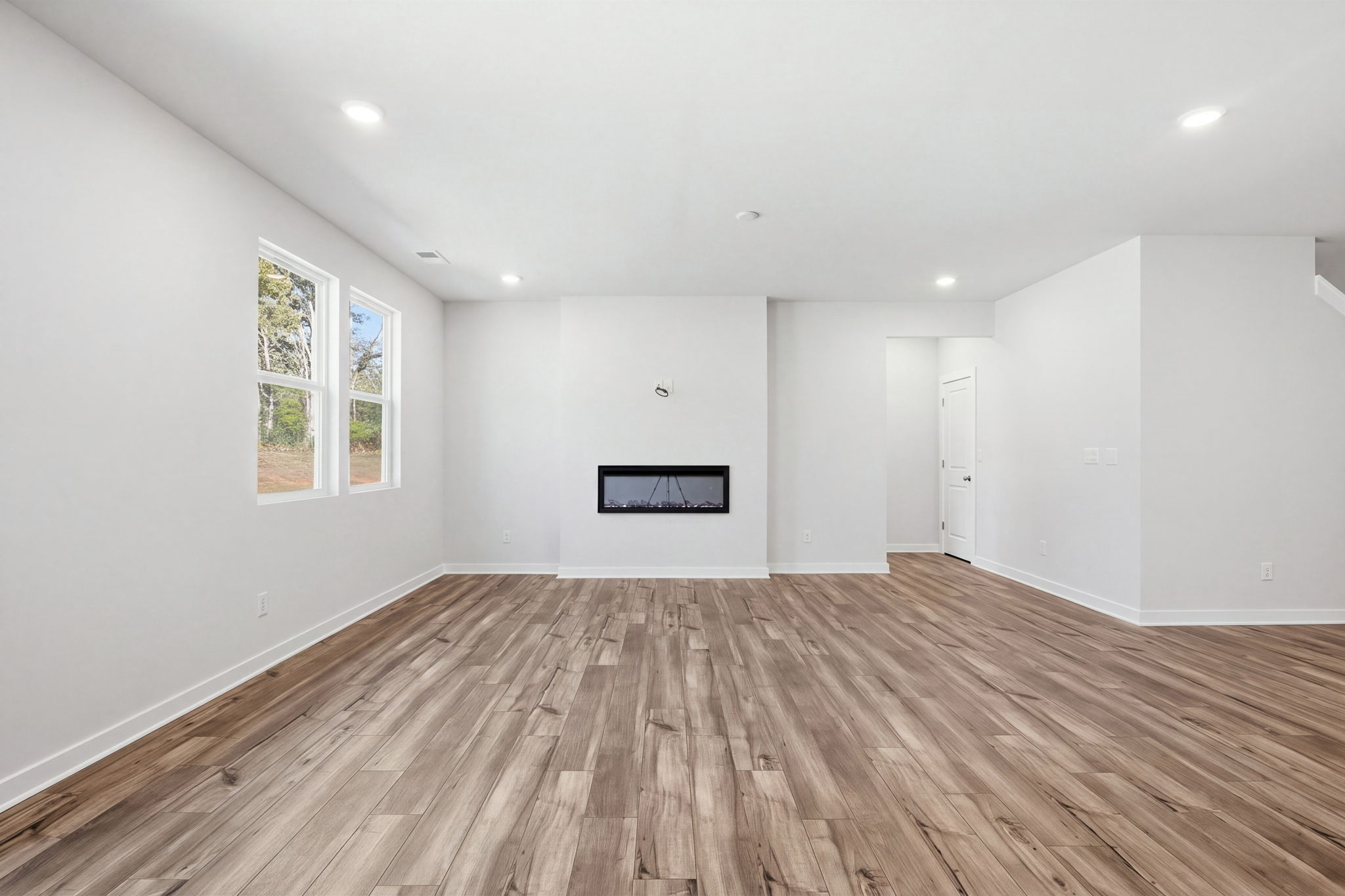 A room with a wood floor and white walls.