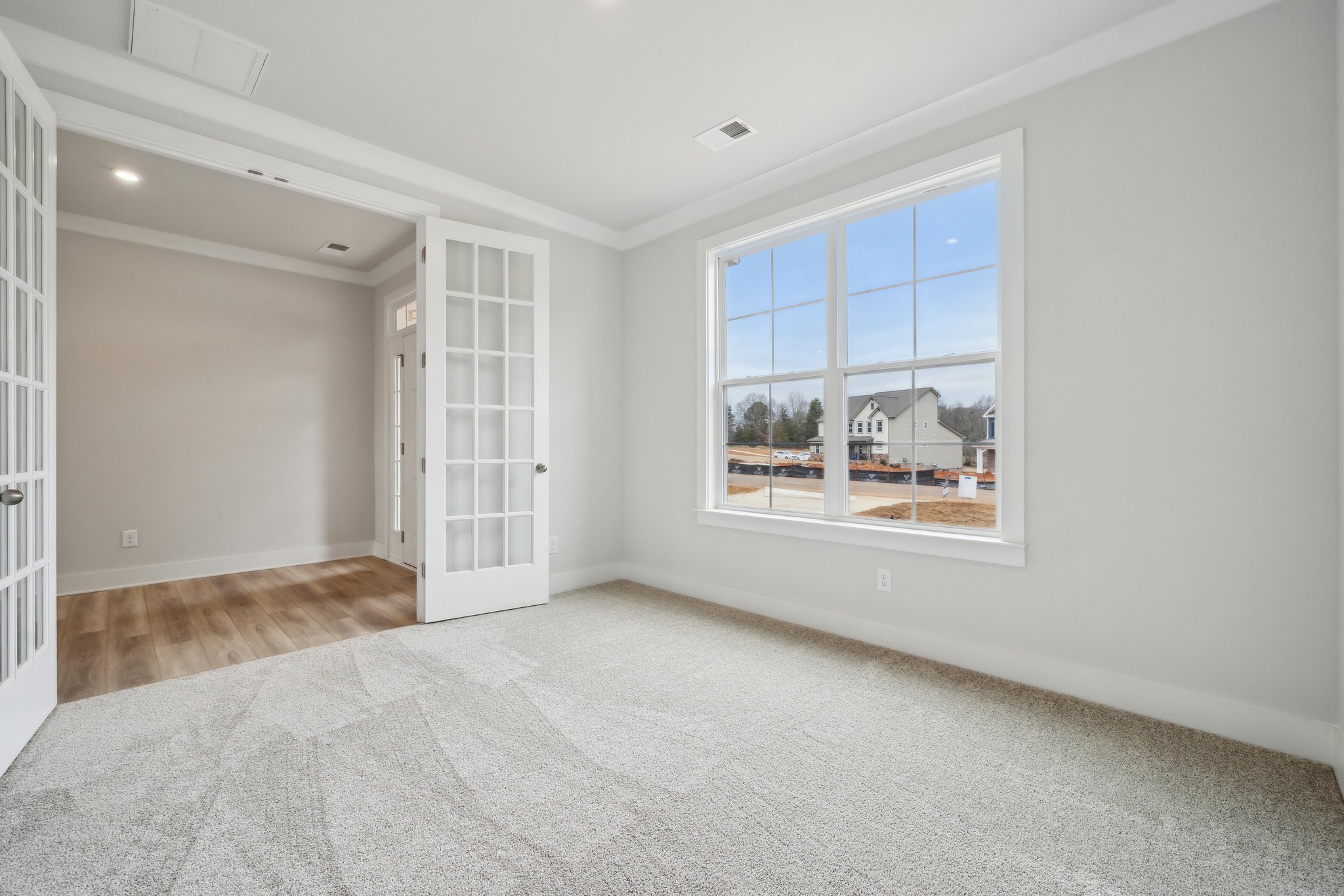 A room with a window and a rug.