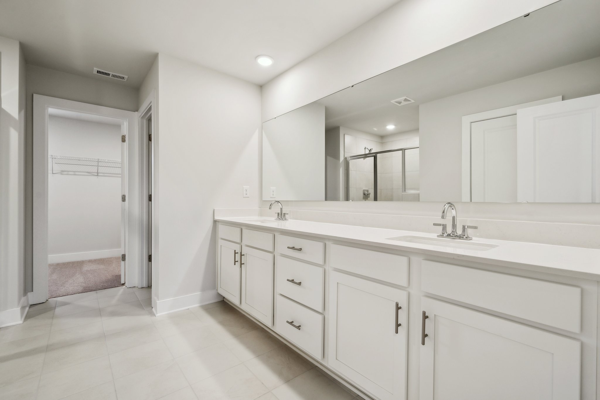 A bathroom with white cabinets.