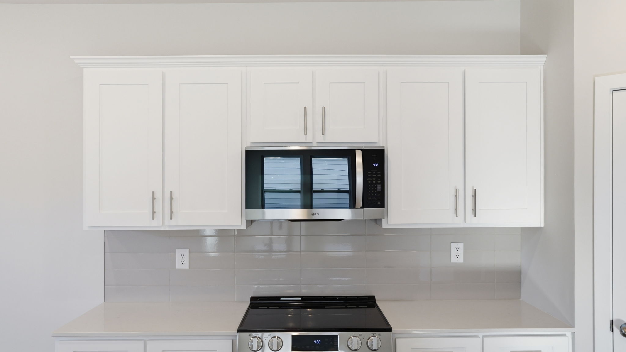 A kitchen with white cabinets.