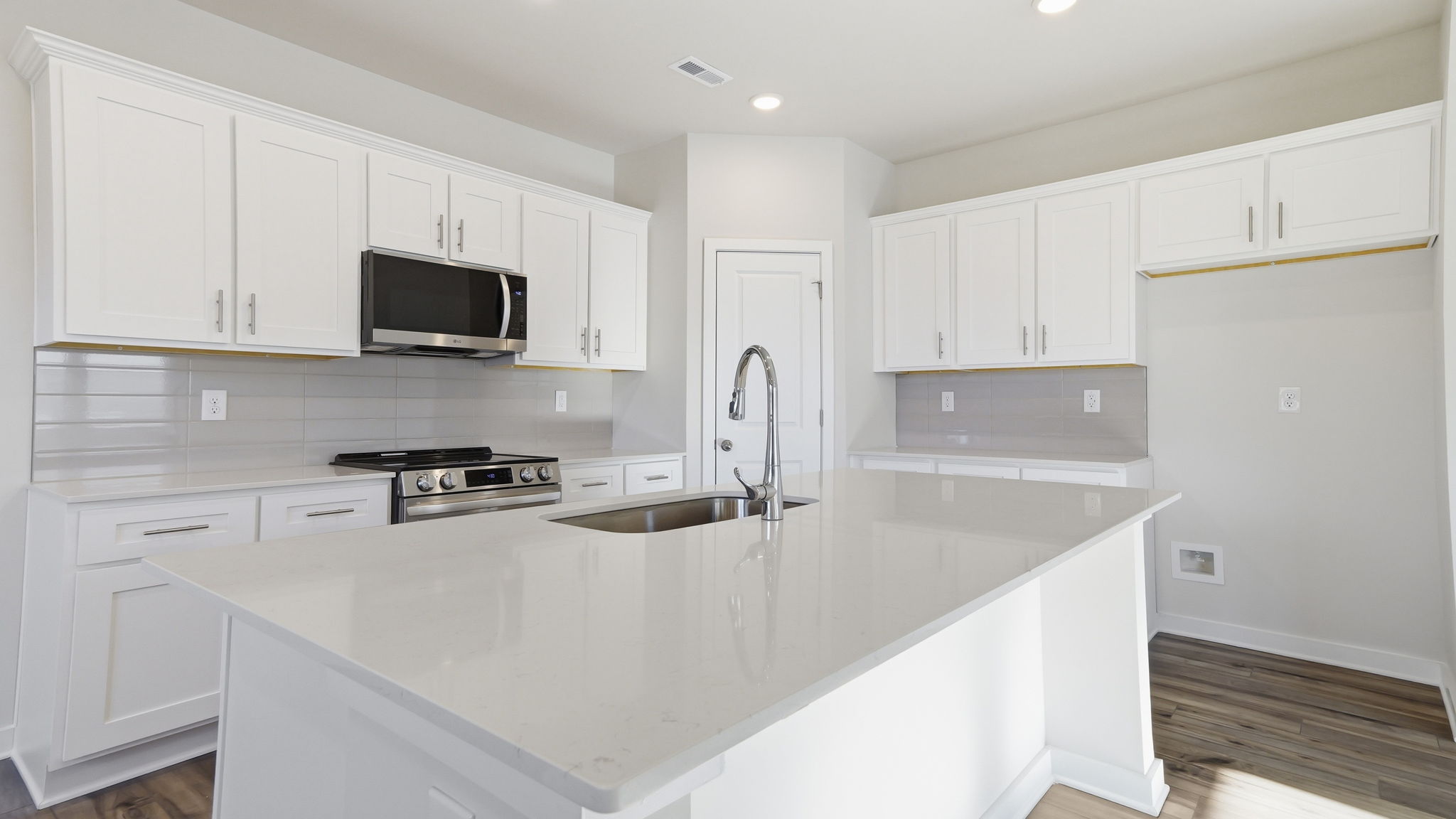 A kitchen with white cabinets.