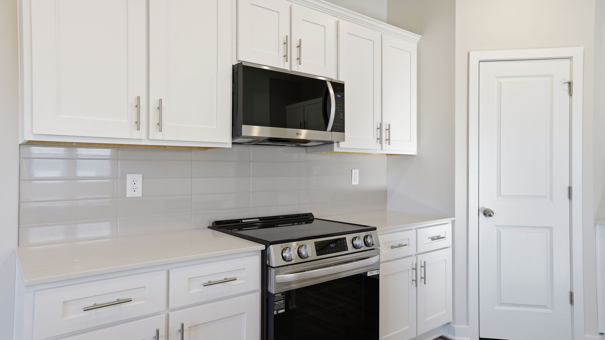 A kitchen with white cabinets.