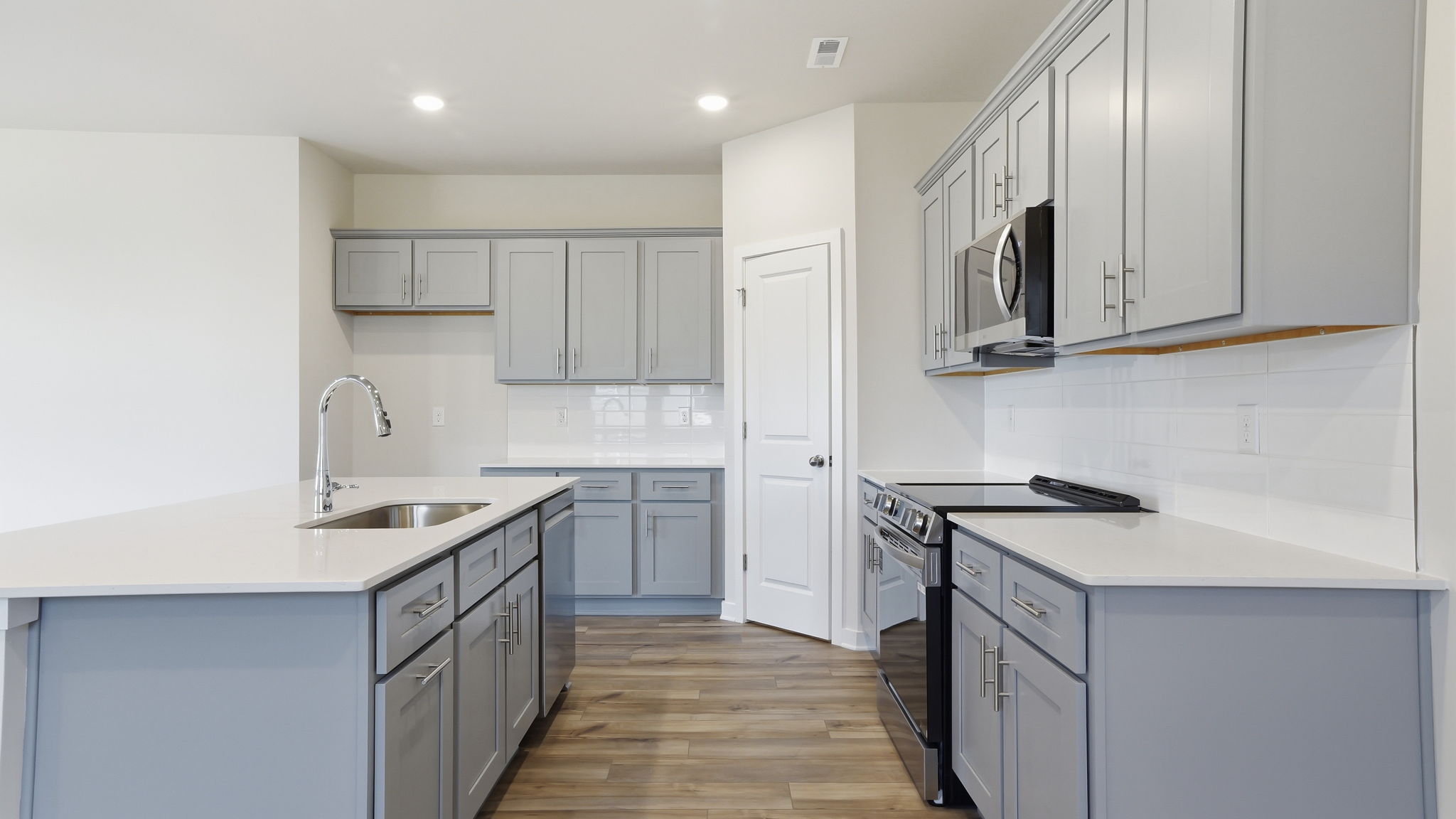 A kitchen with white cabinets.