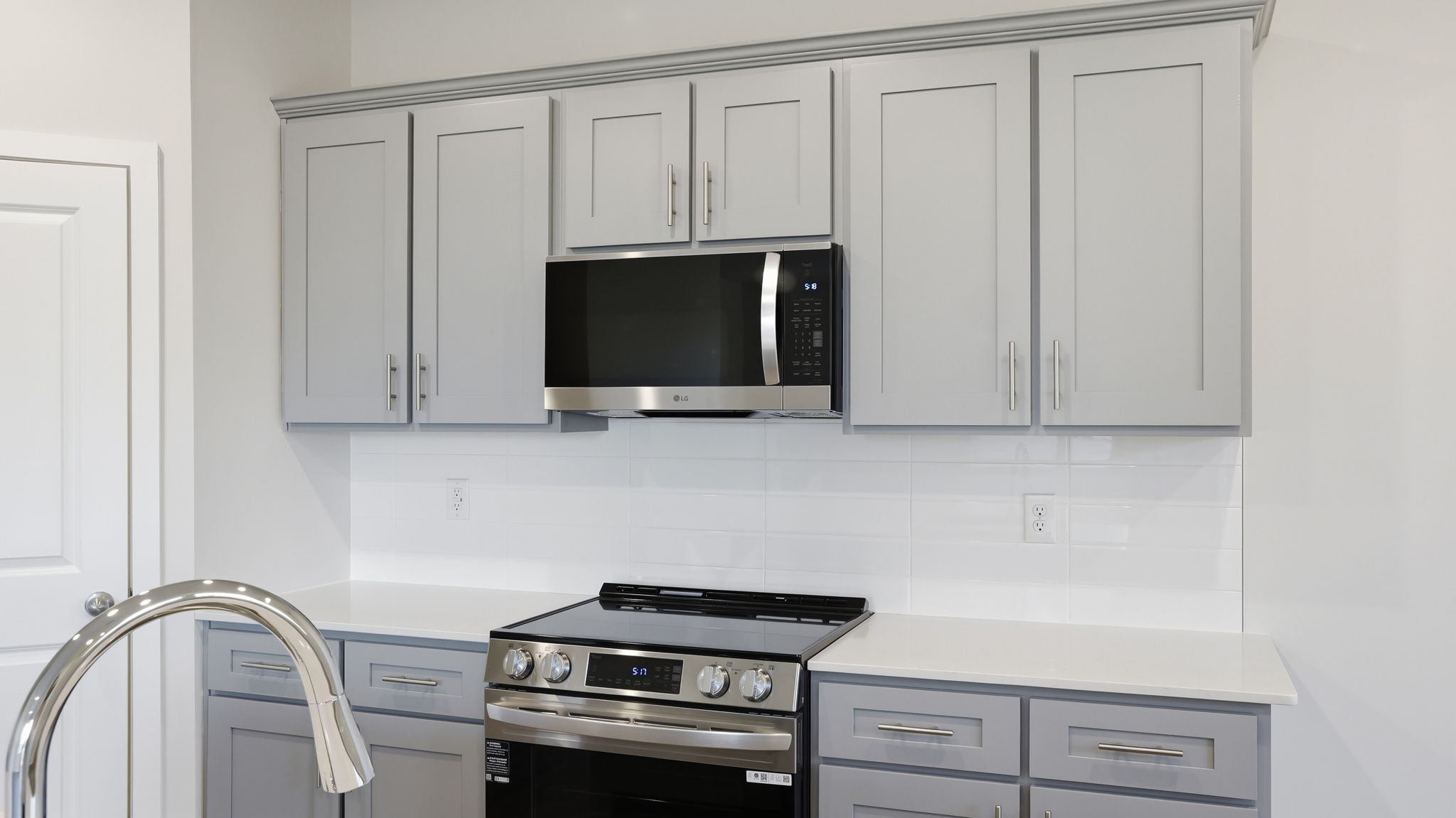 A kitchen with white cabinets.