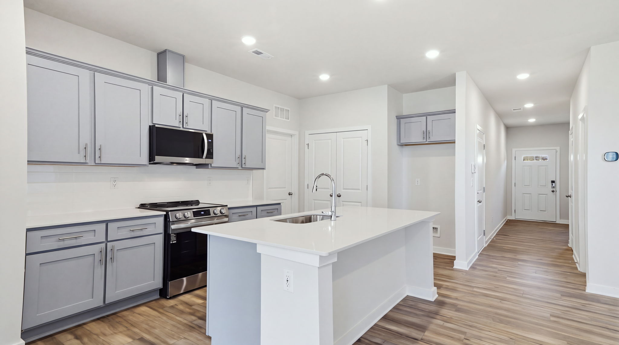 A kitchen with white cabinets.