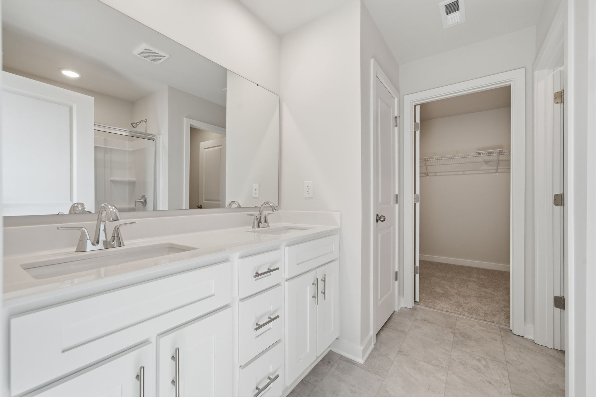 A bathroom with white cabinets.