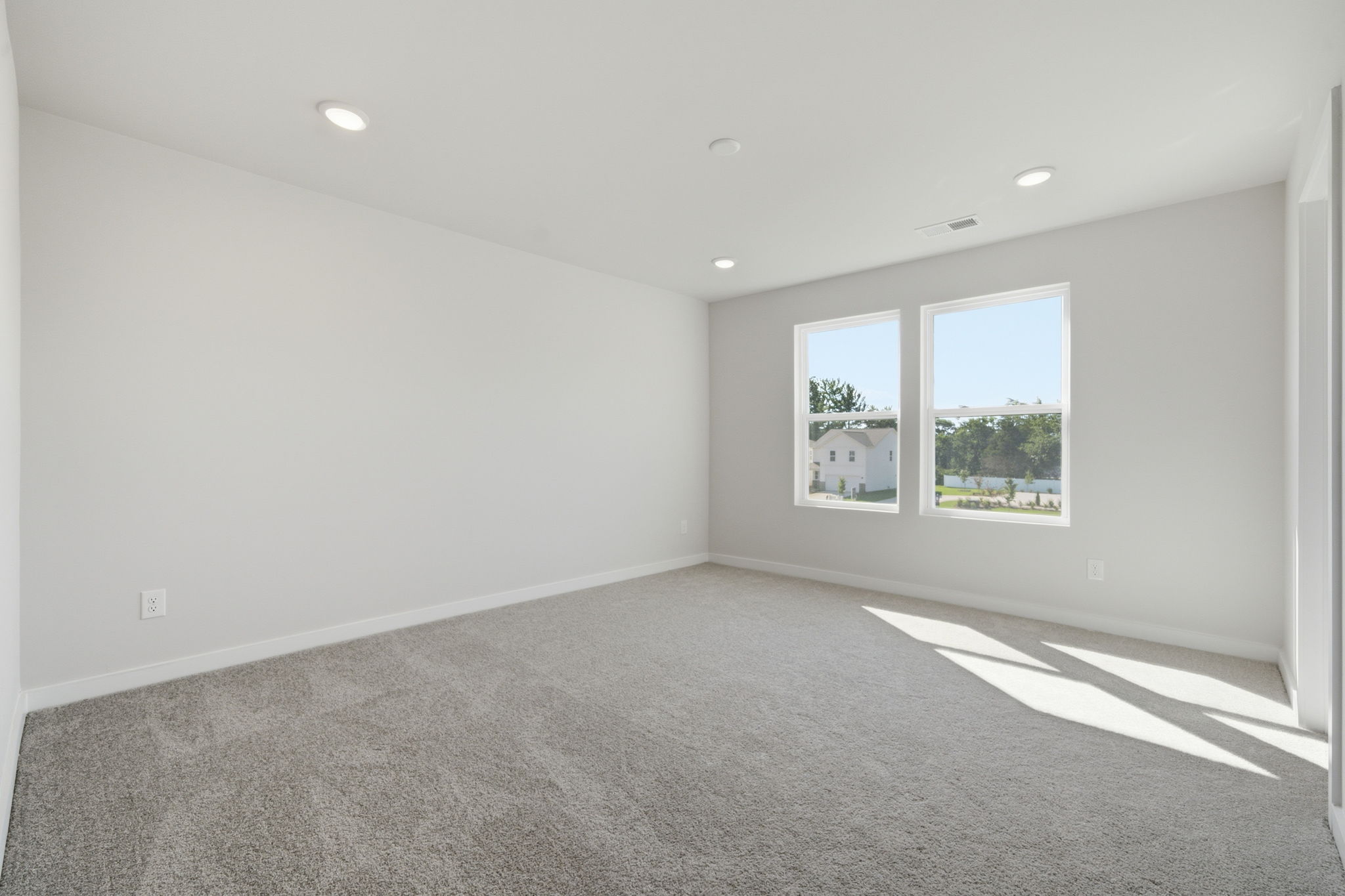 A room with a window and a carpet.