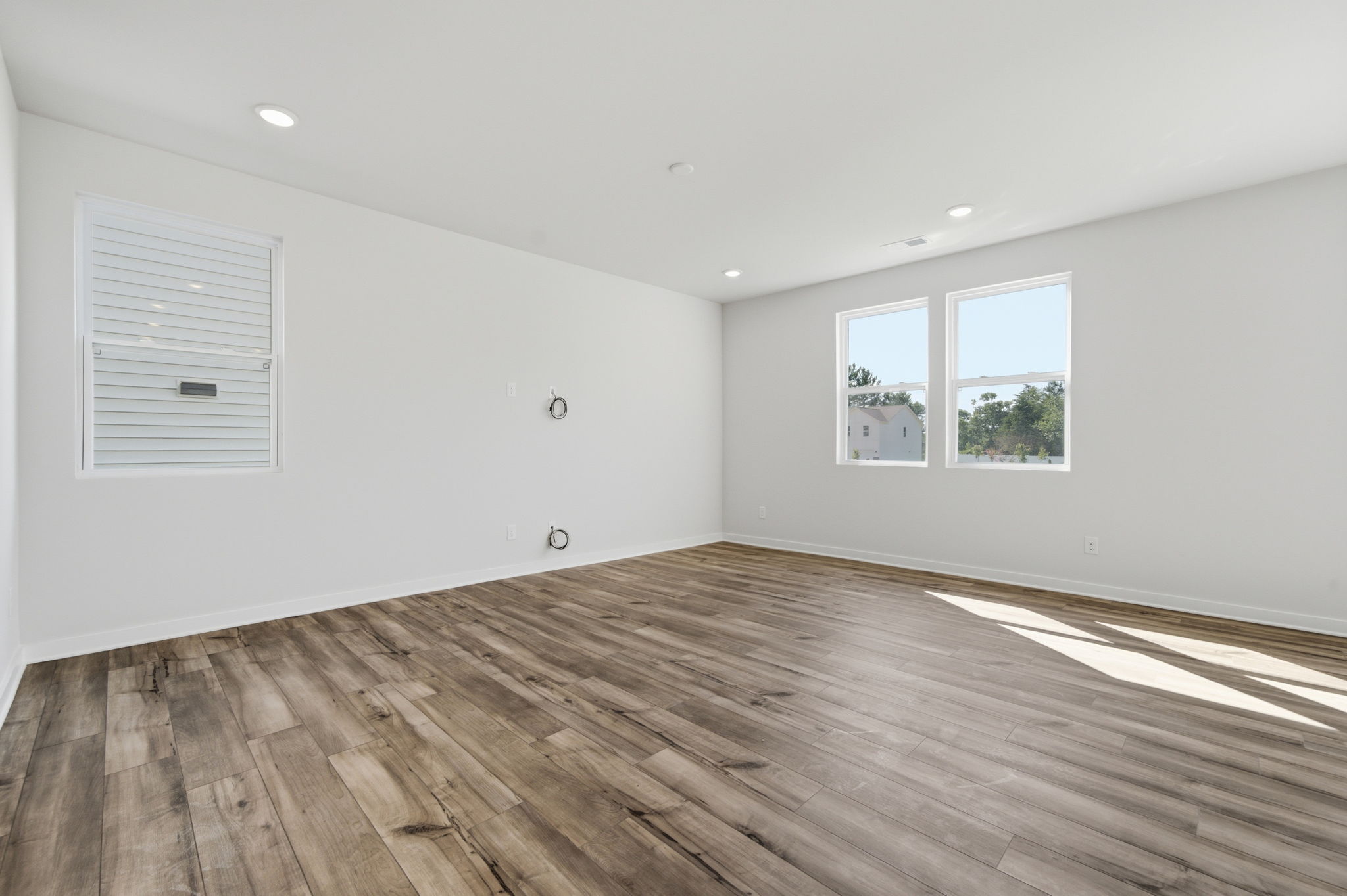 A room with a wood floor and windows.