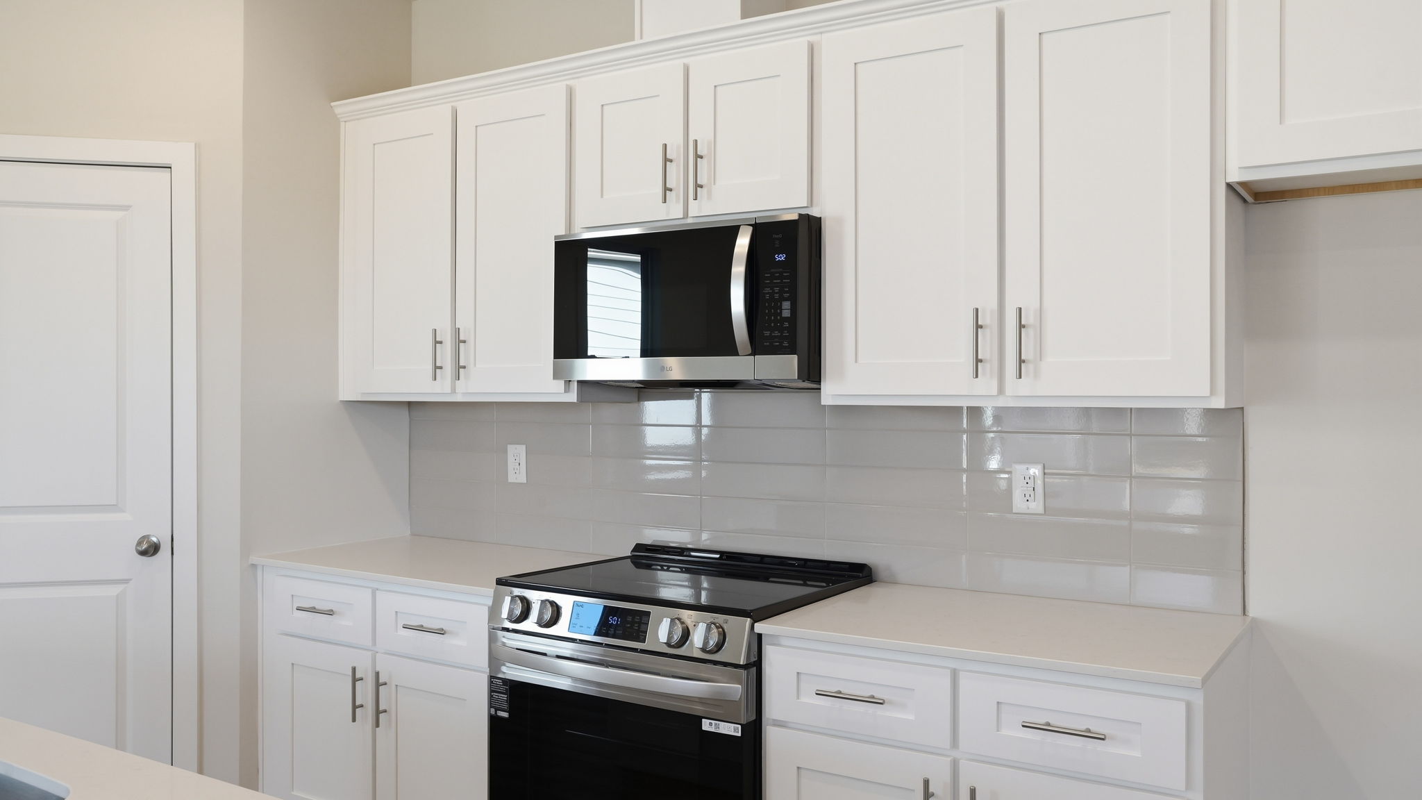 A kitchen with white cabinets.