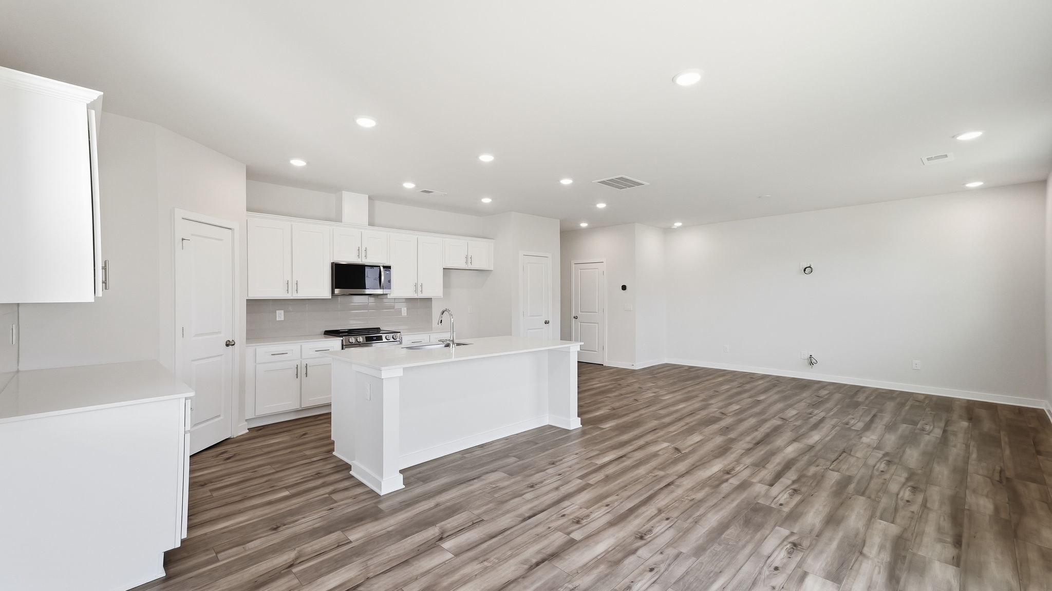 A kitchen with white cabinets.
