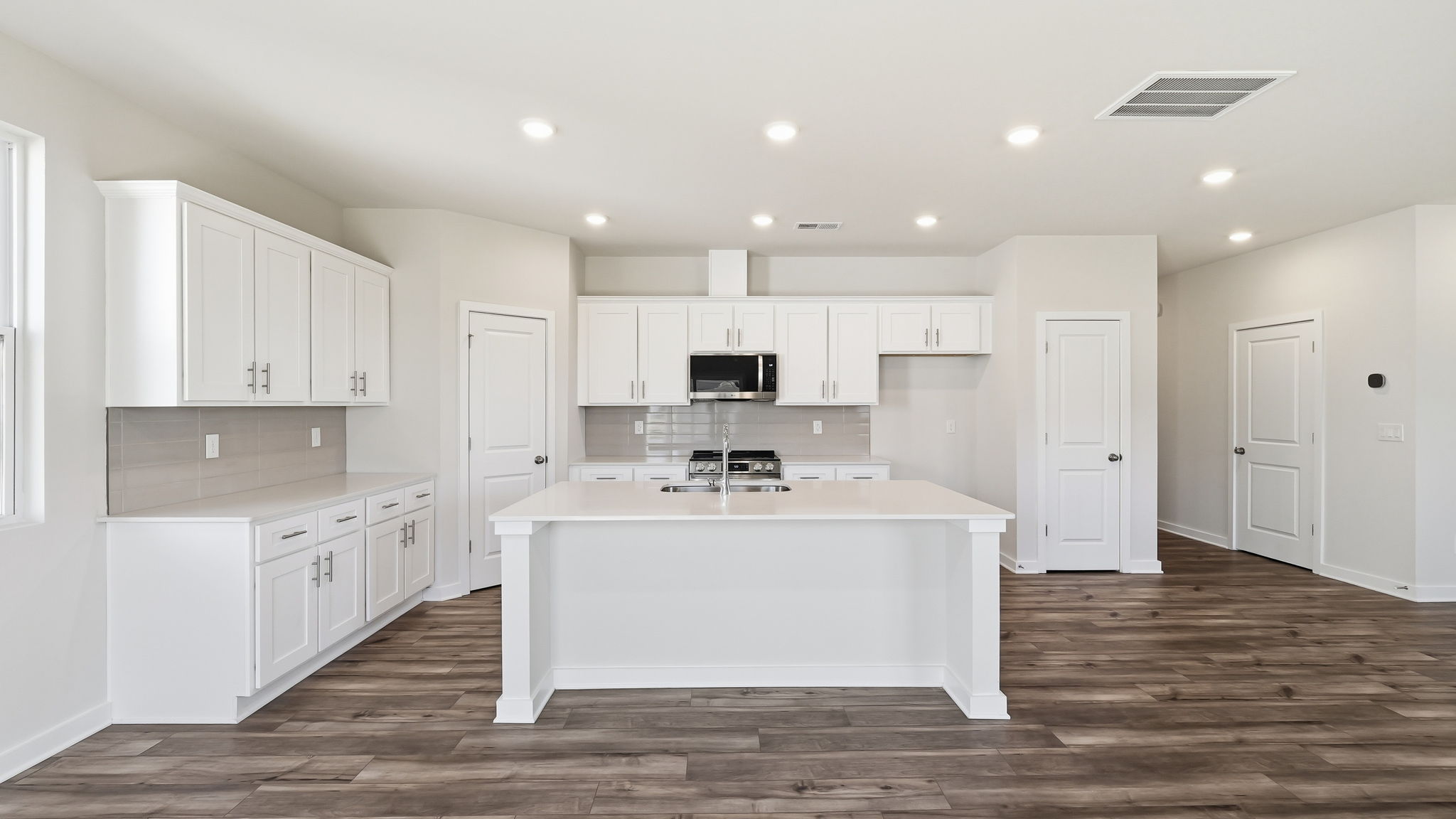 A kitchen with white cabinets.