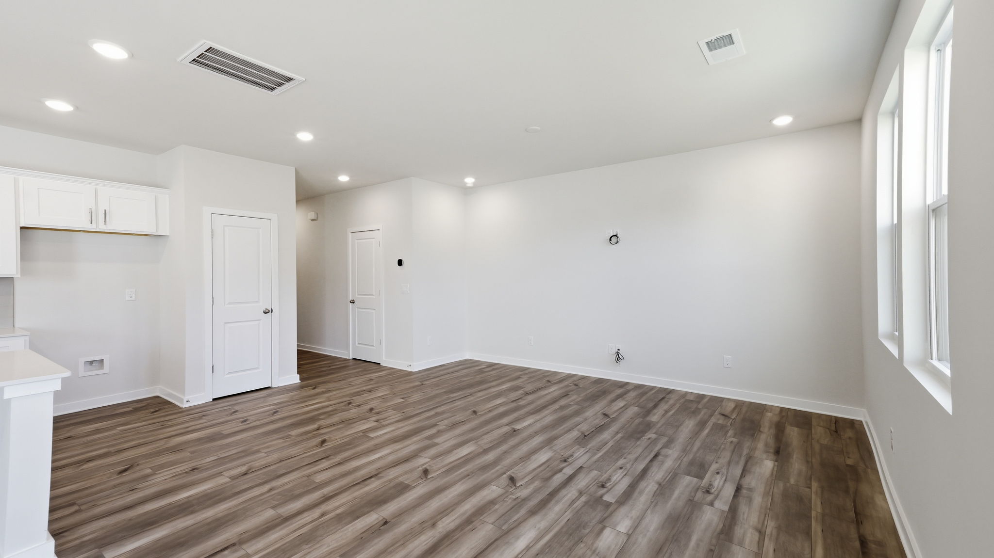 A room with white walls and wood floors.