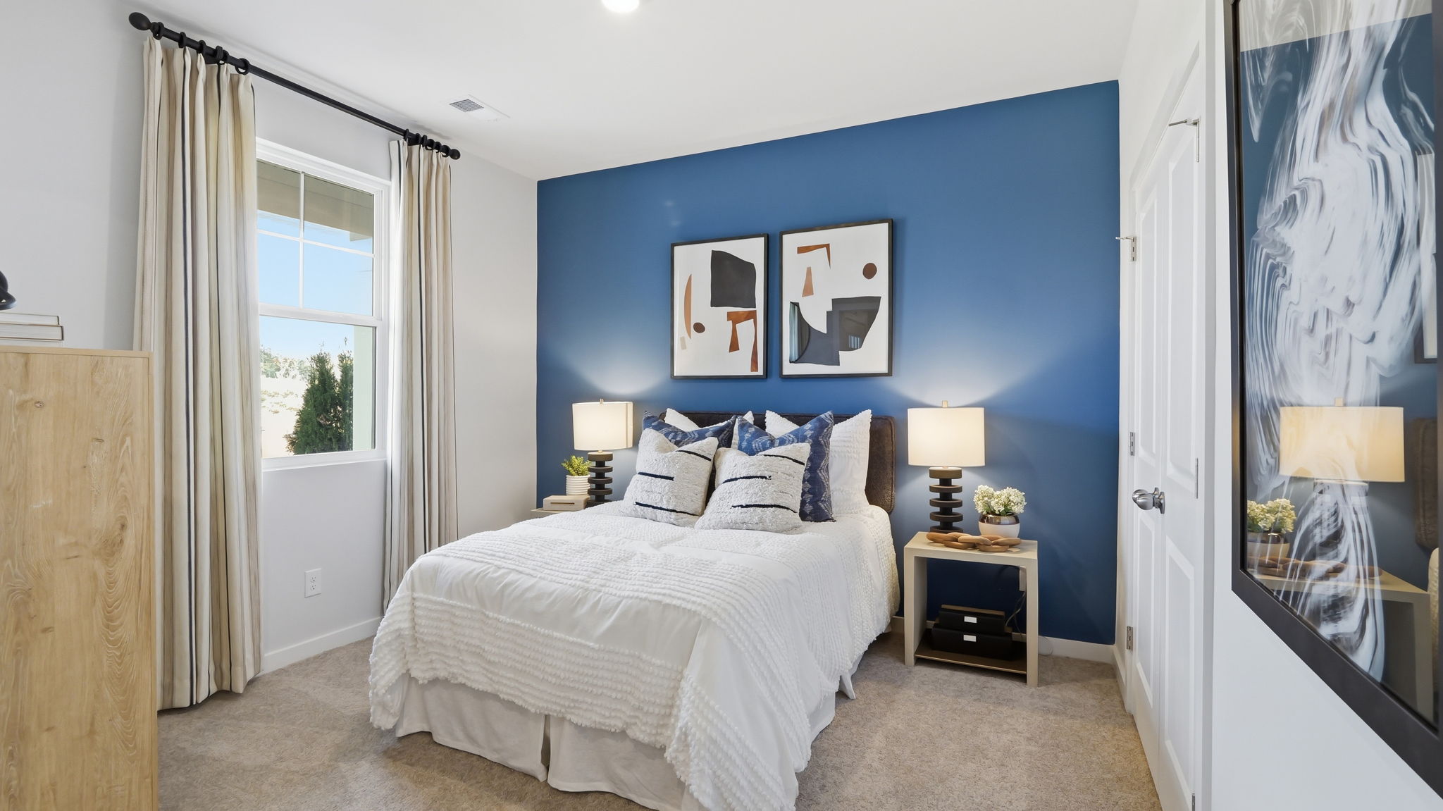 A bedroom with a bed and a lamp.