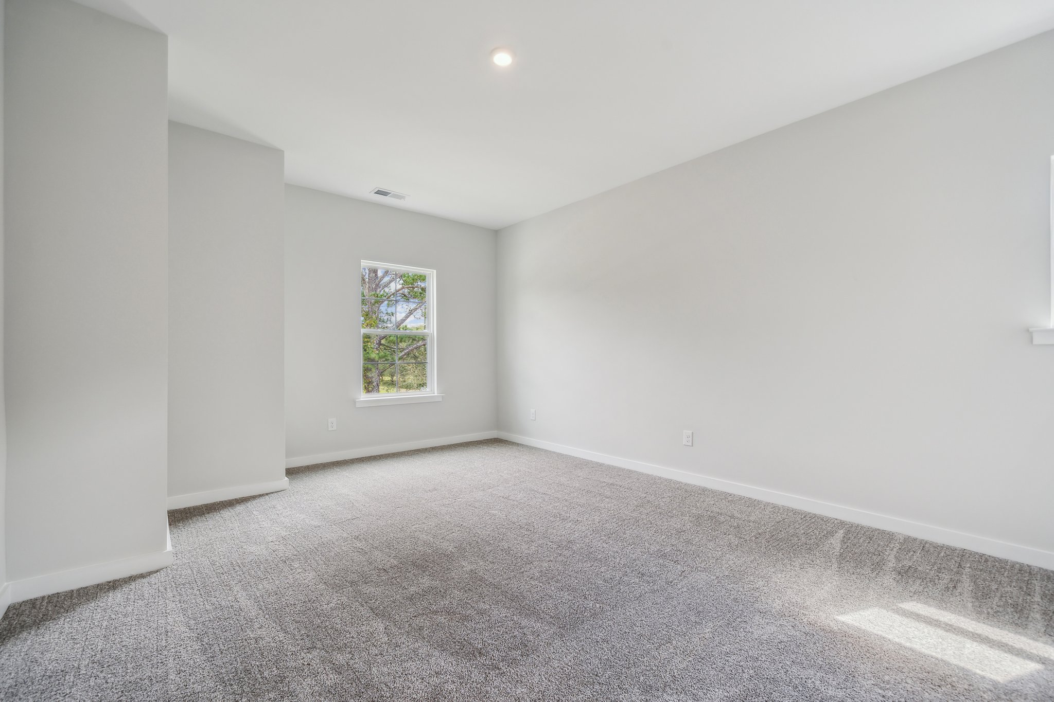 A room with a window and a carpet.