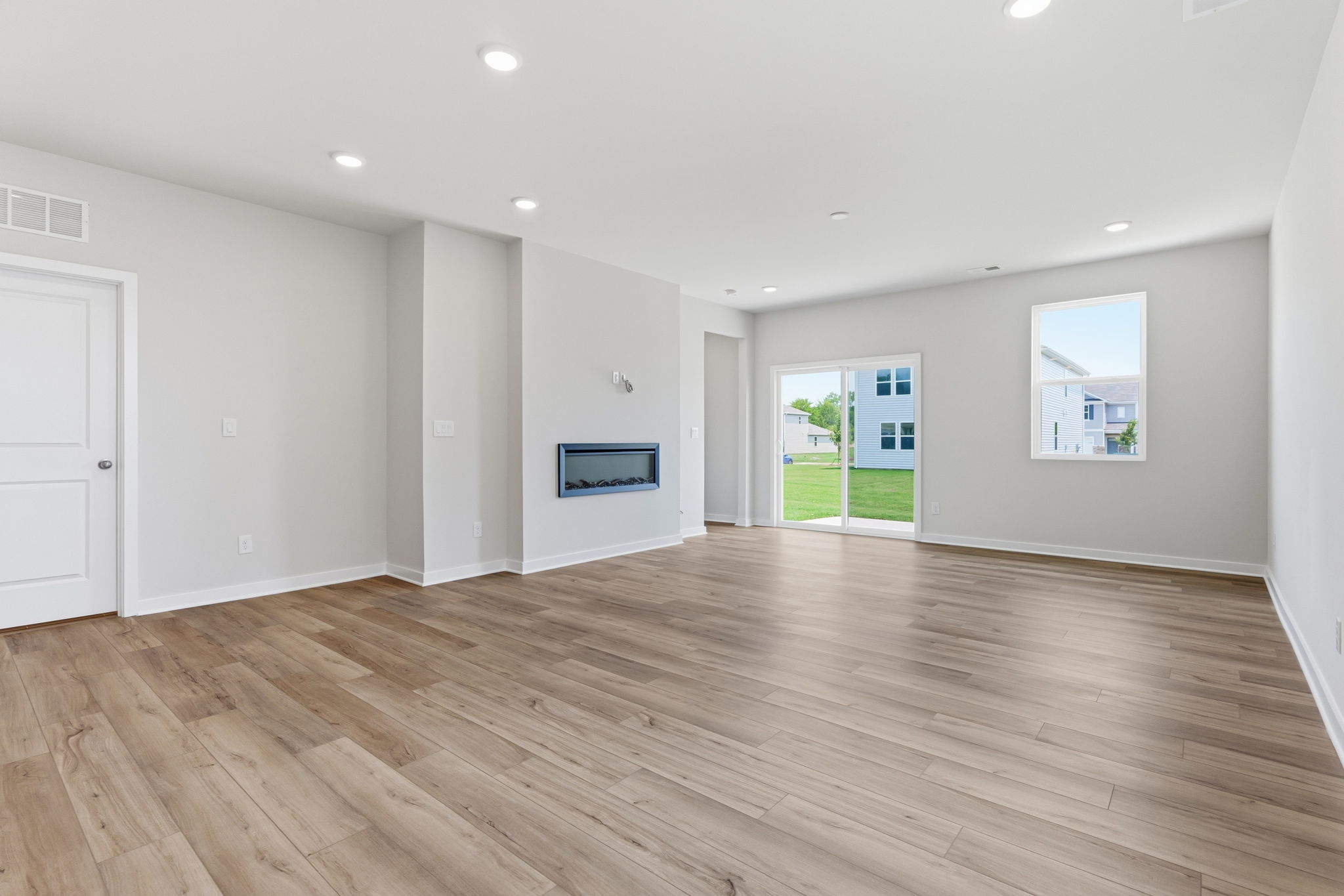 A large empty room with a wood floor and a wood floor.