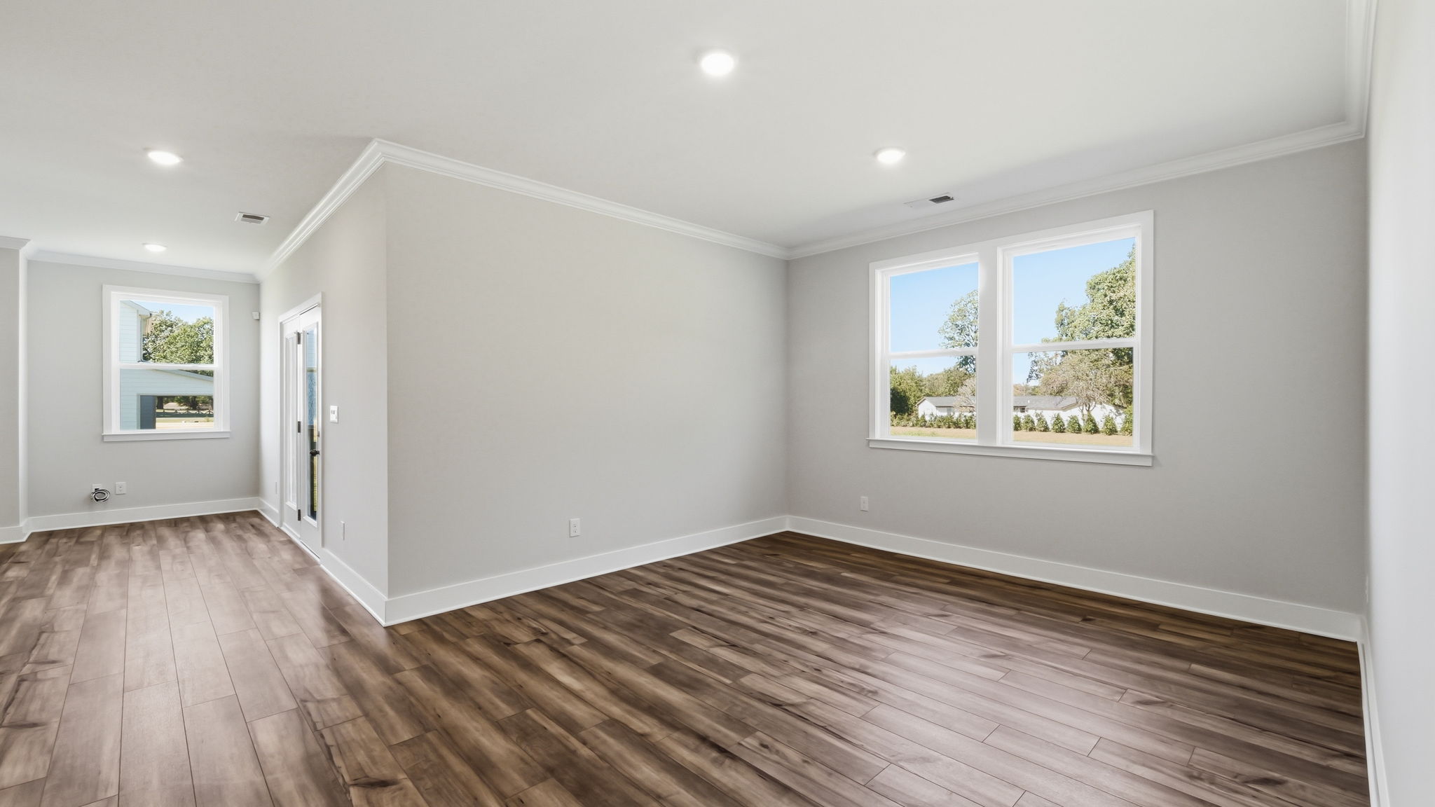 A room with a wood floor and windows.
