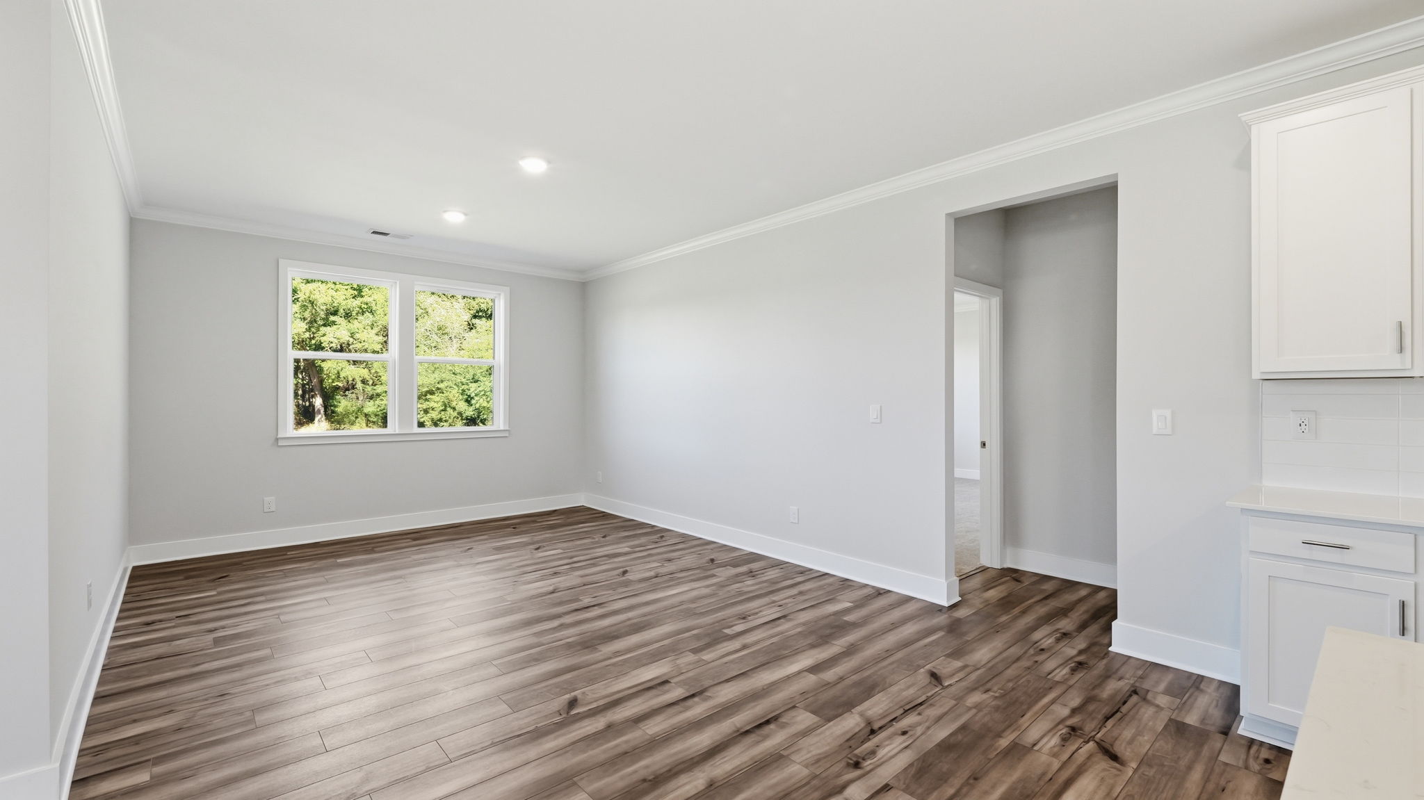 A room with a wood floor and white walls.