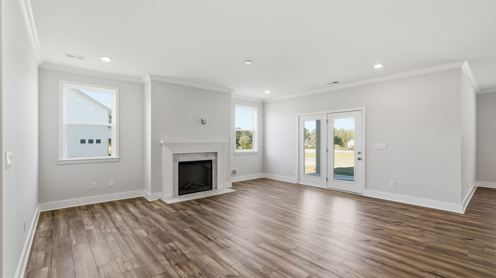 A room with a fireplace and a wood floor.