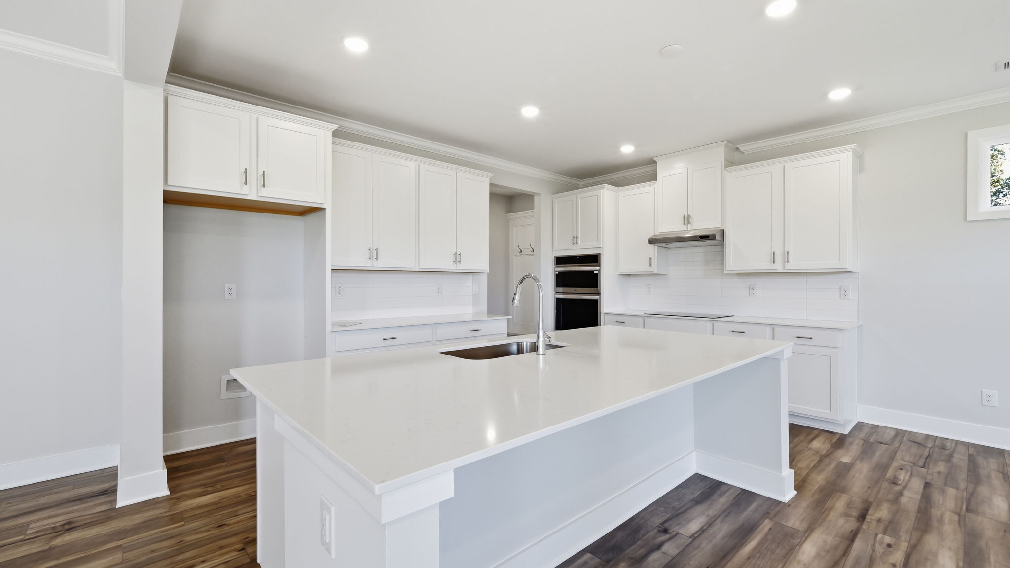 A kitchen with white cabinets.