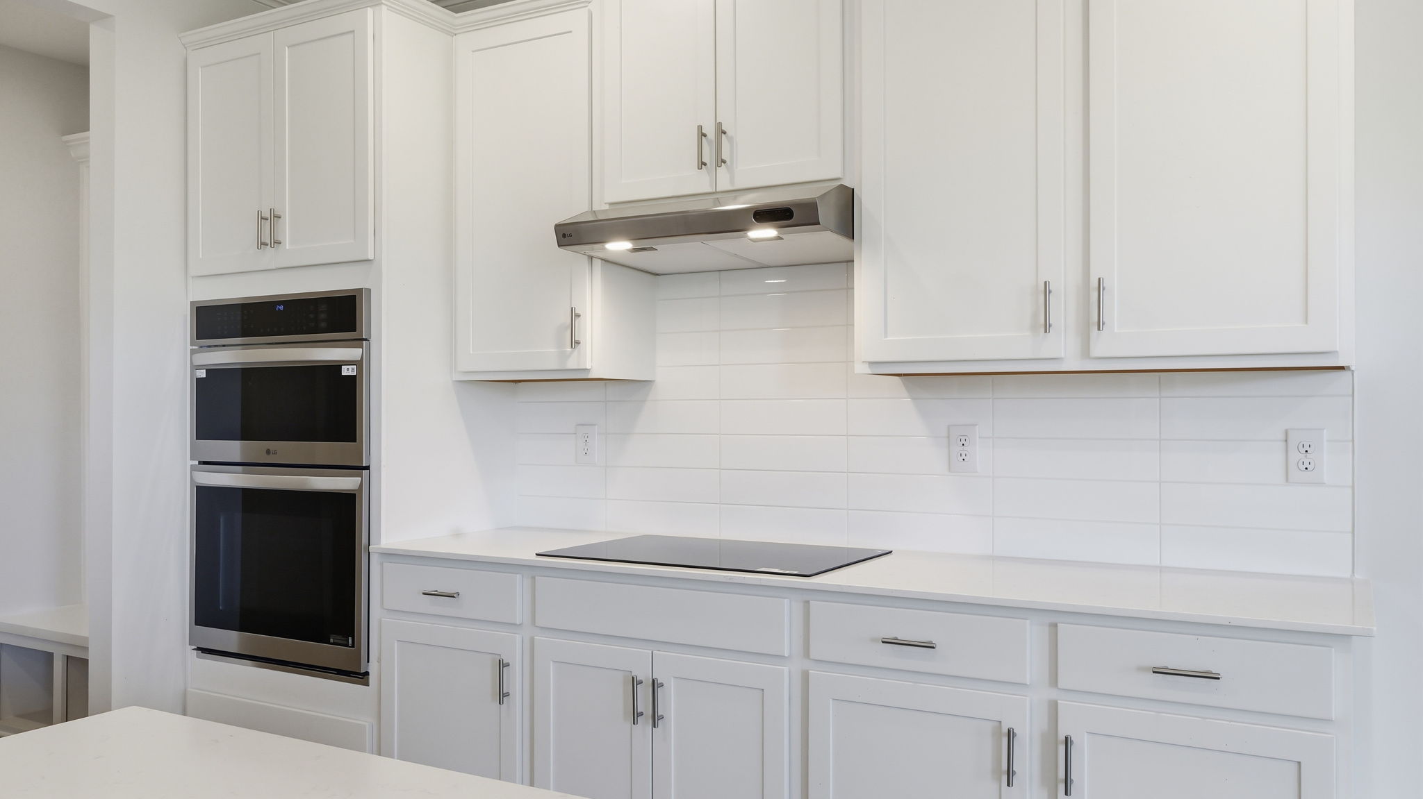 A kitchen with white cabinets.