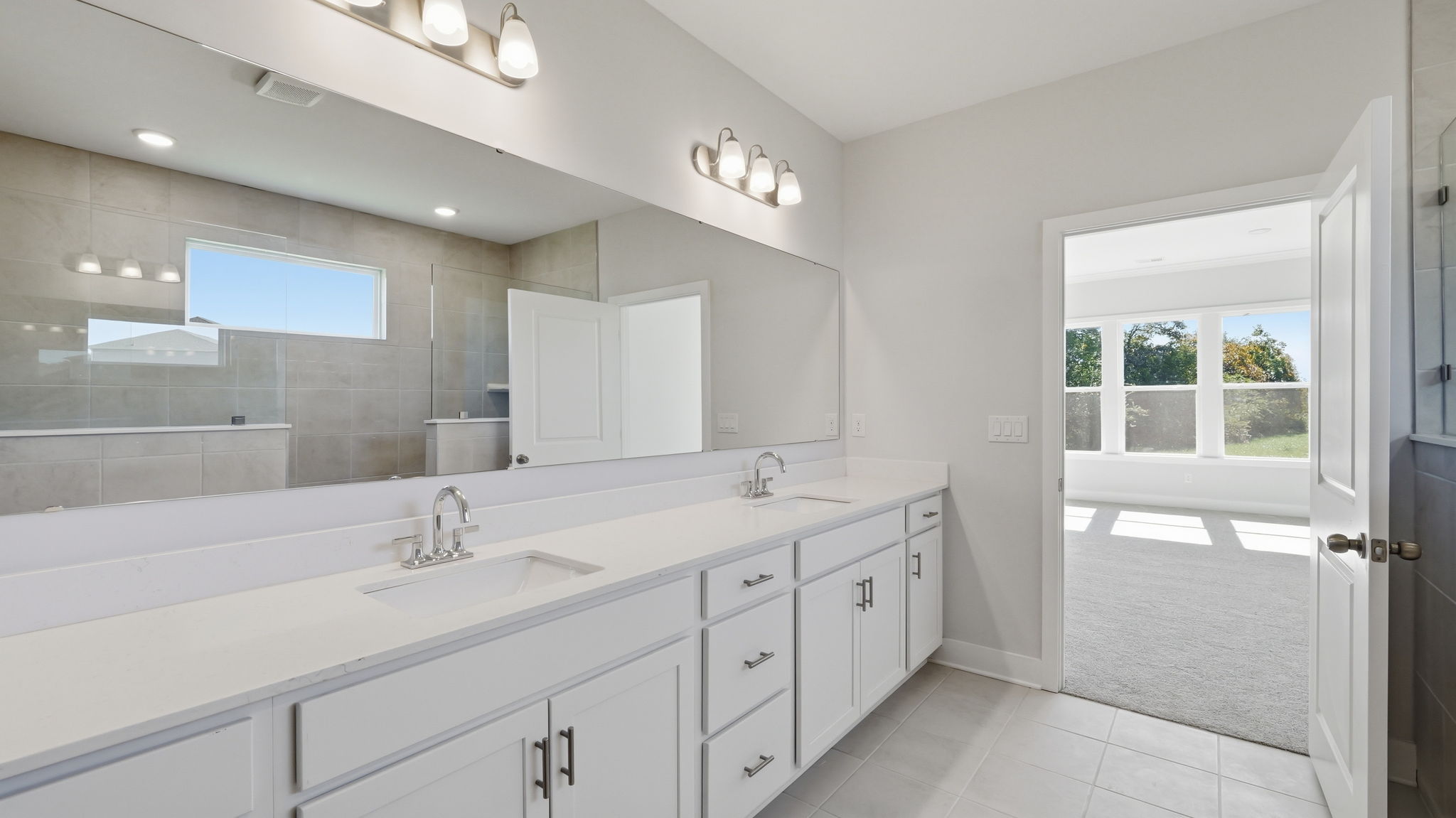A bathroom with white cabinets.