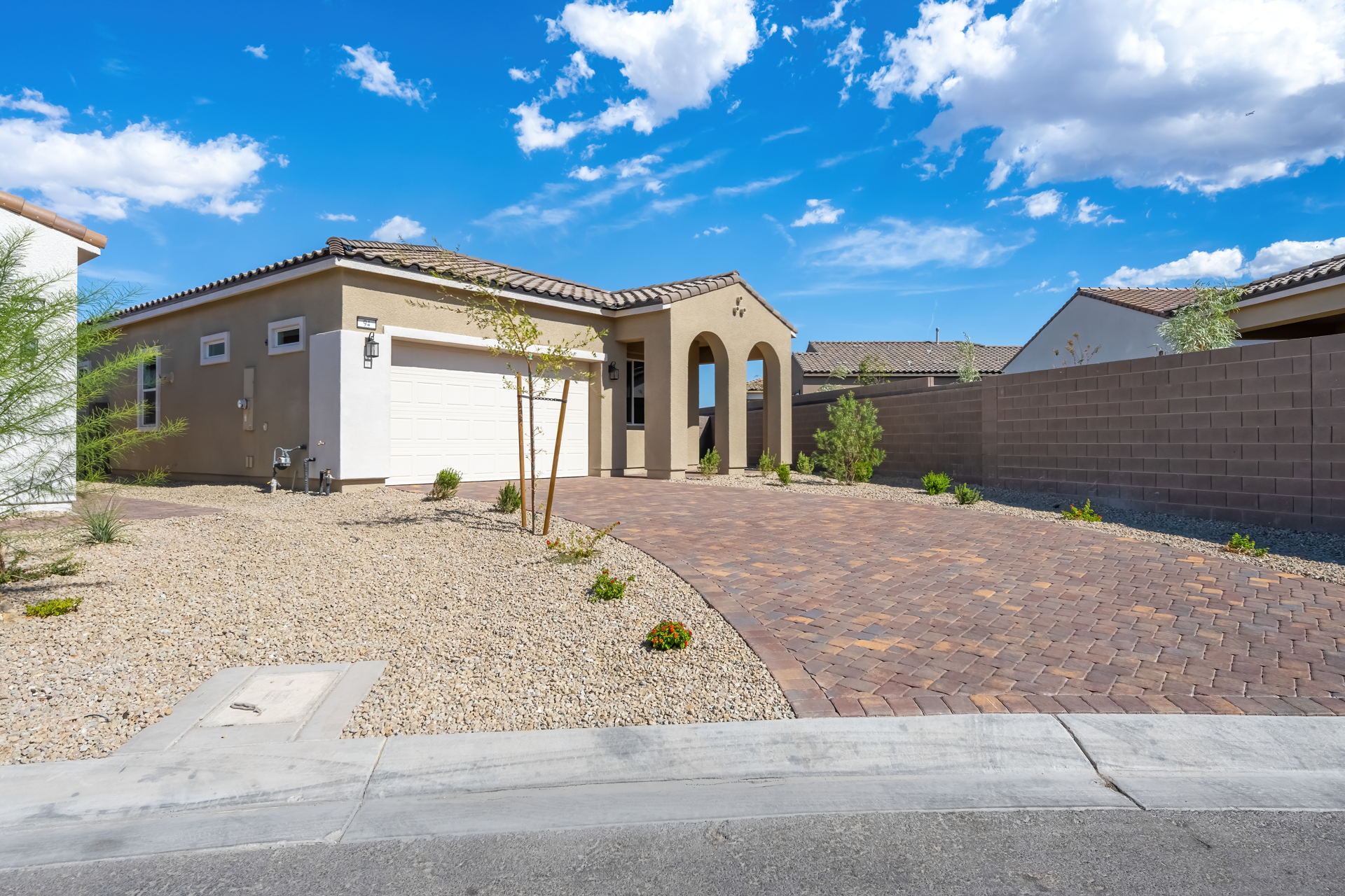 A brick driveway leading to a house.
