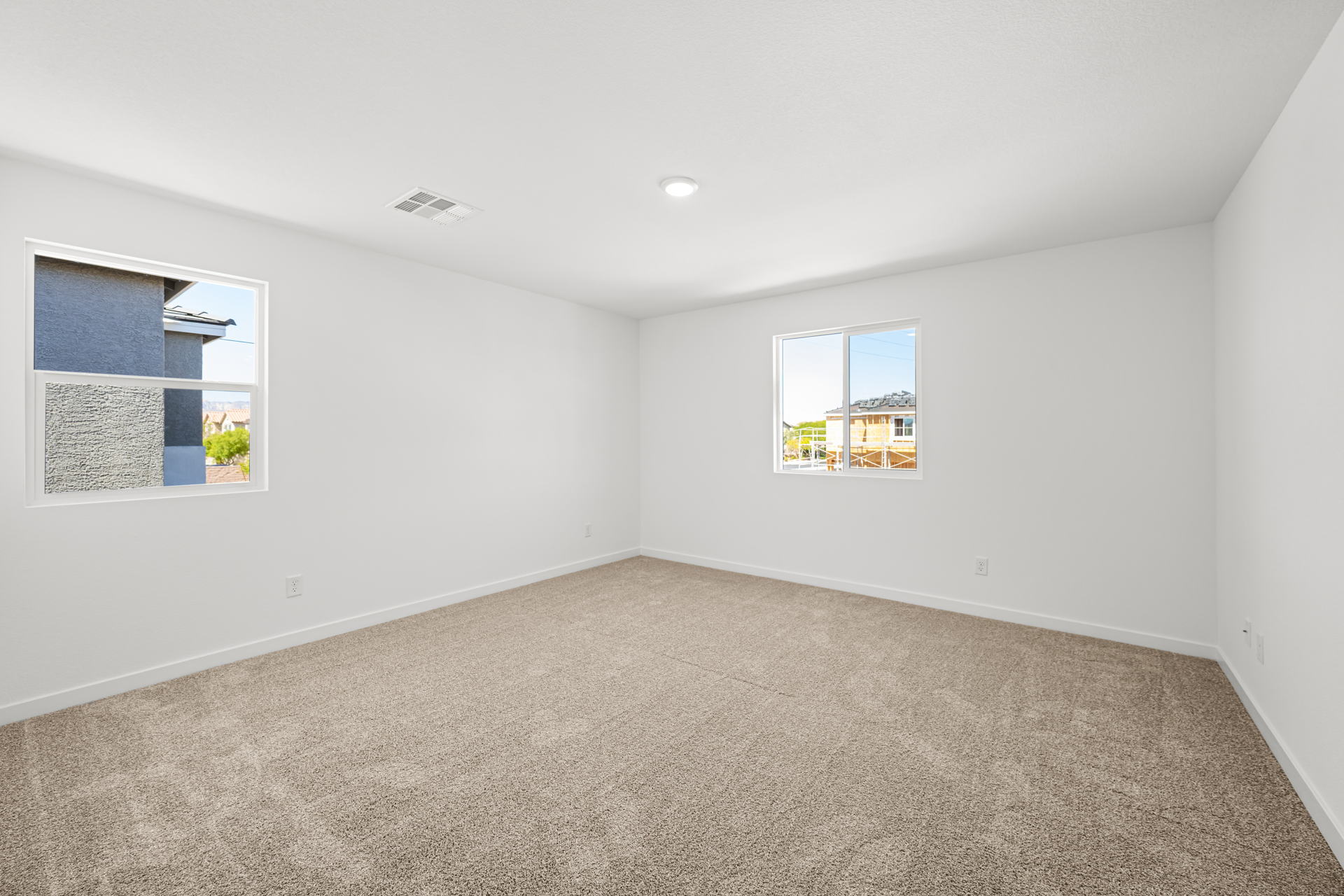 A room with a carpet and windows.