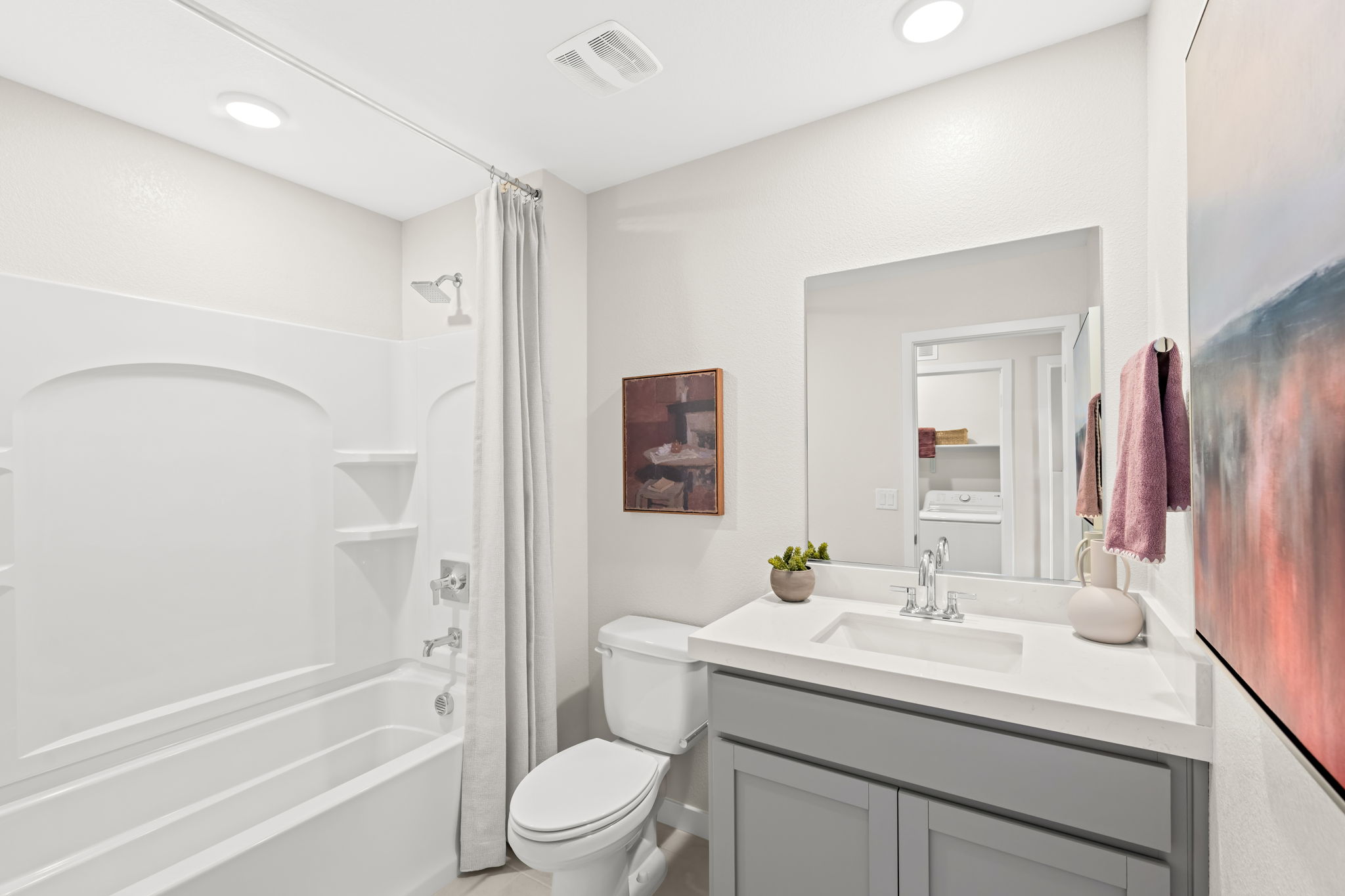 A bathroom with a tub sink and toilet.
