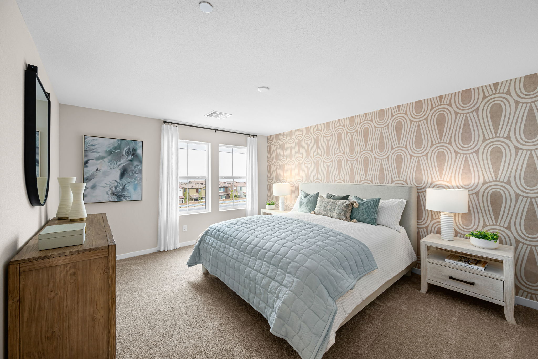 A bedroom with a bed and lamps.