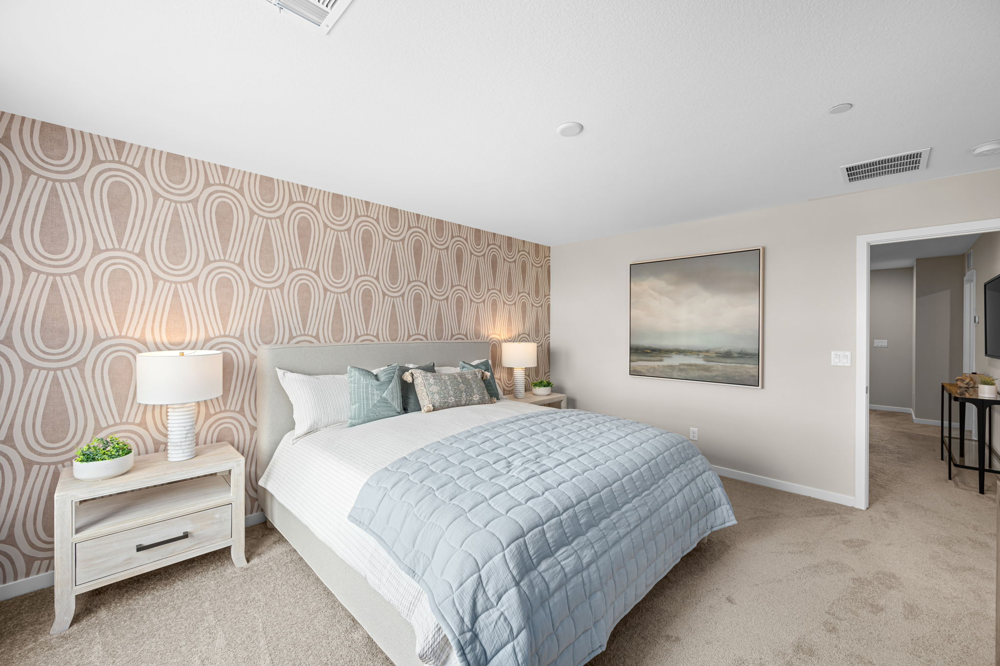 A bedroom with a bed and lamps.