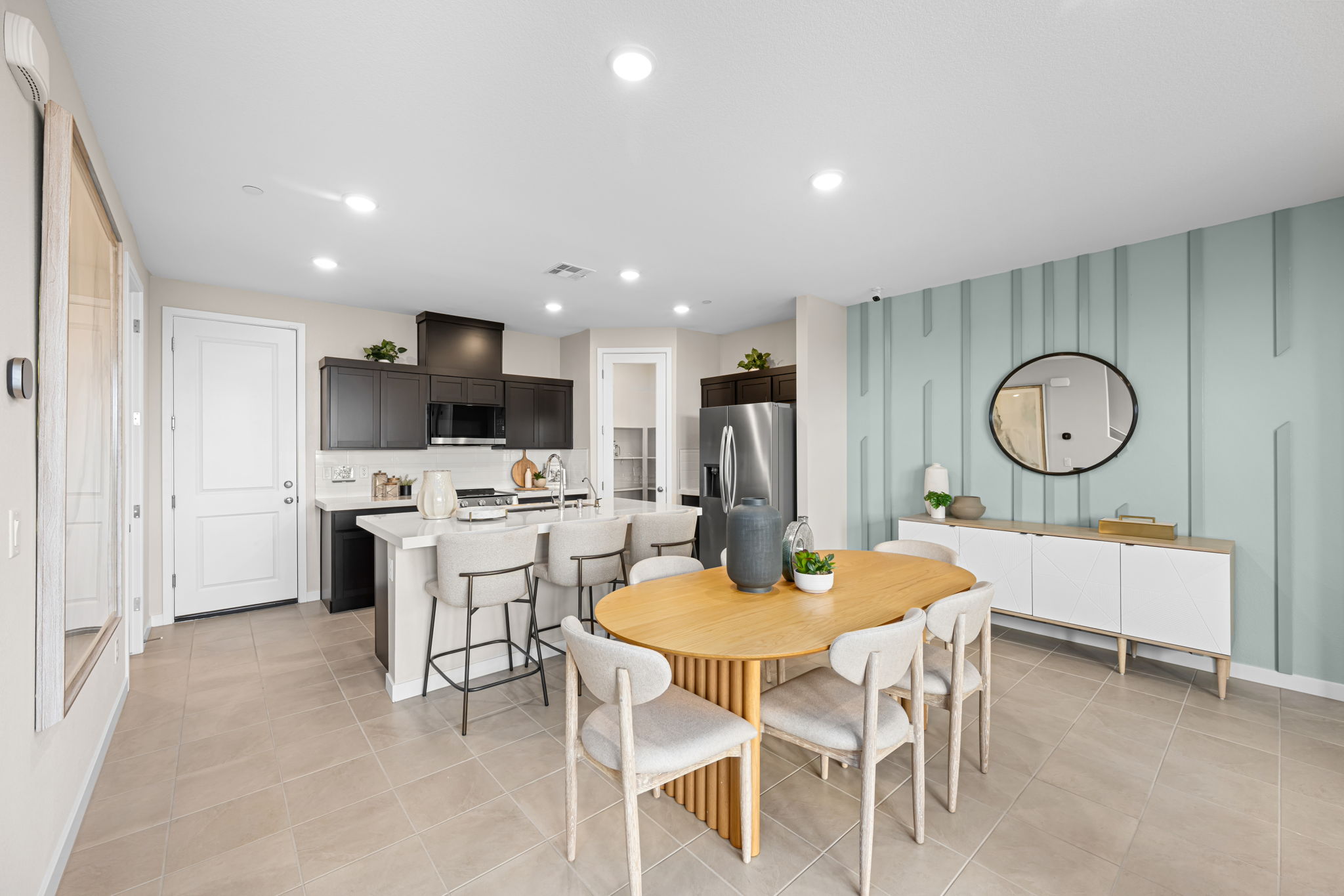 A kitchen with a dining table and chairs.