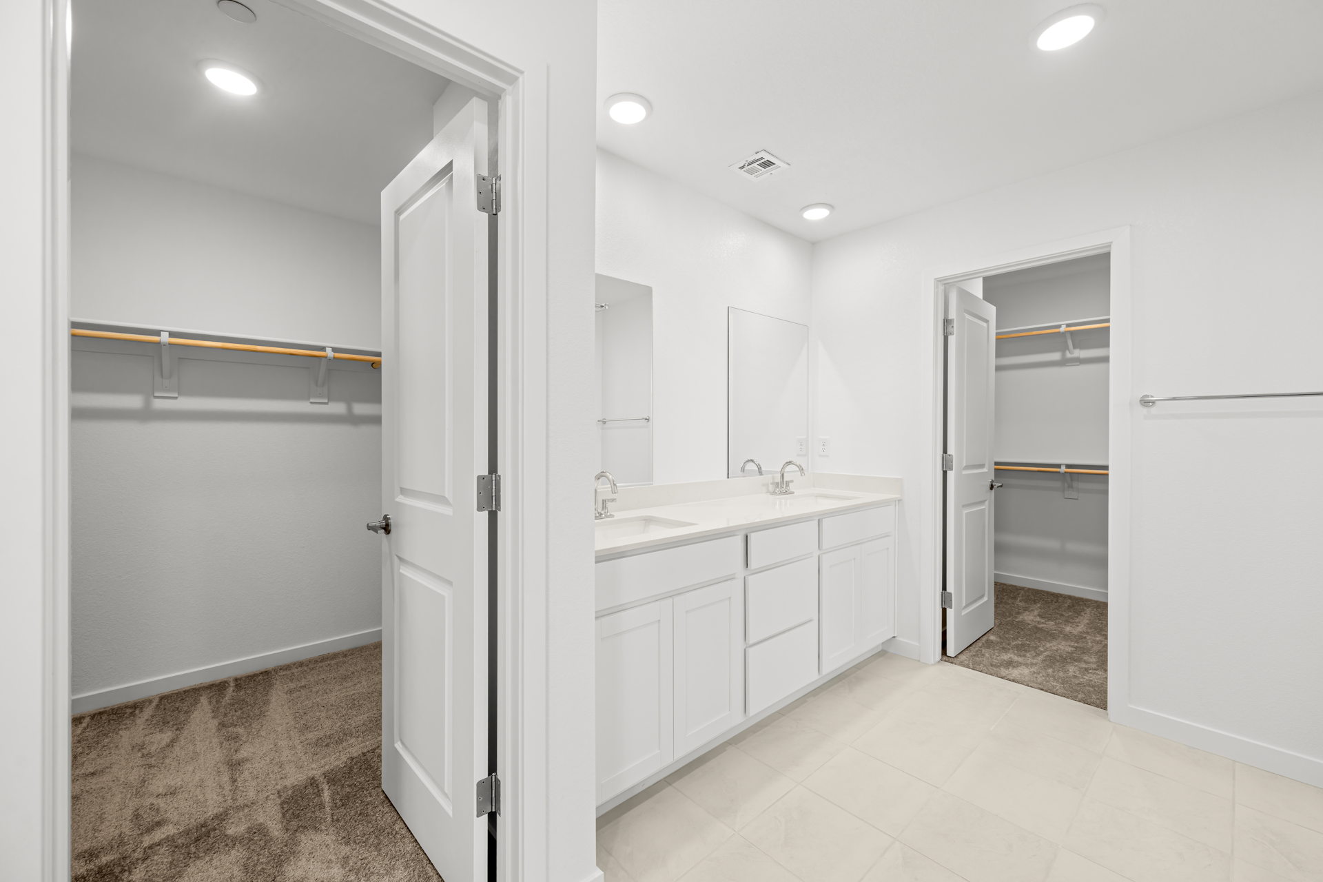 A bathroom with white cabinets.