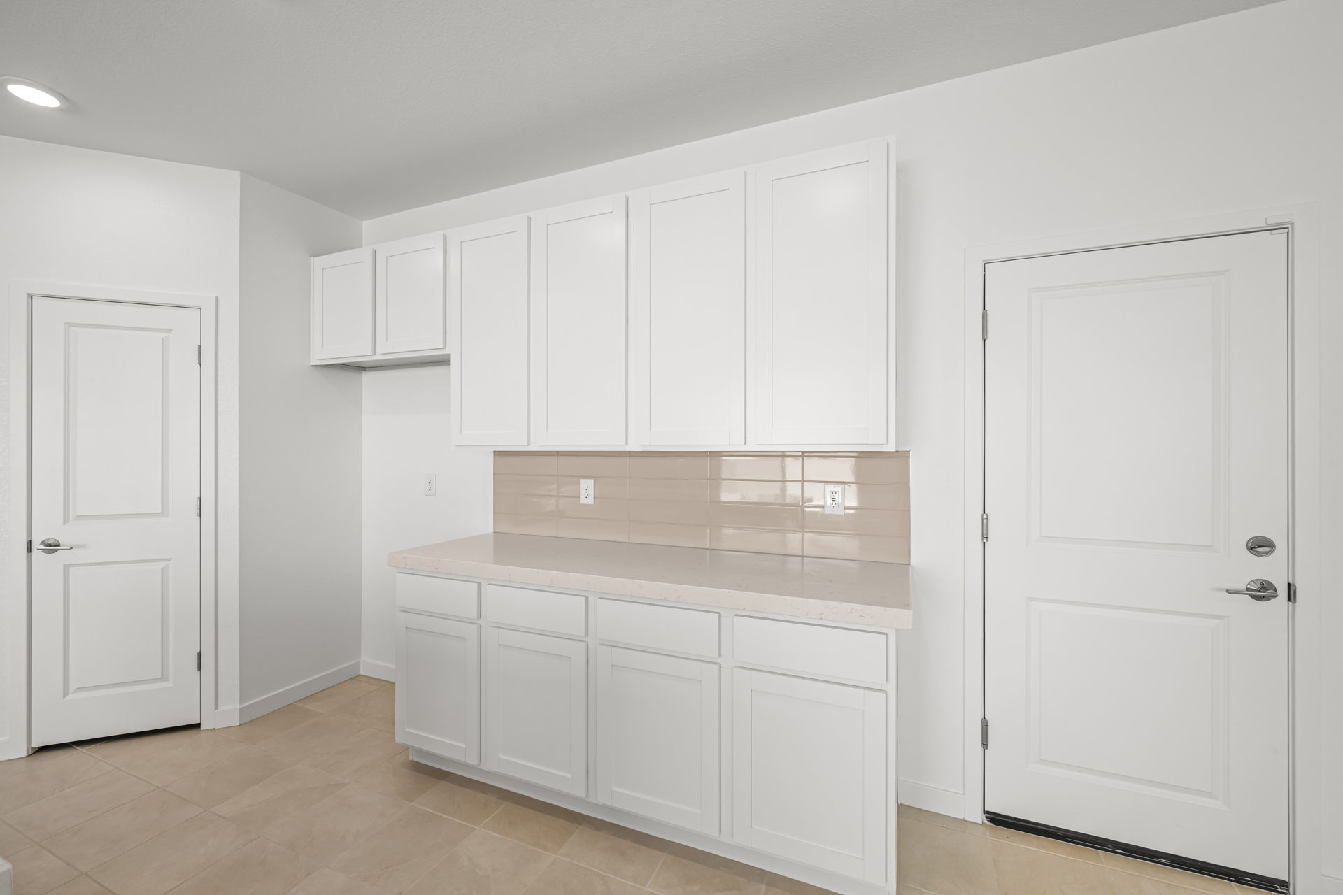 A kitchen with white cabinets.